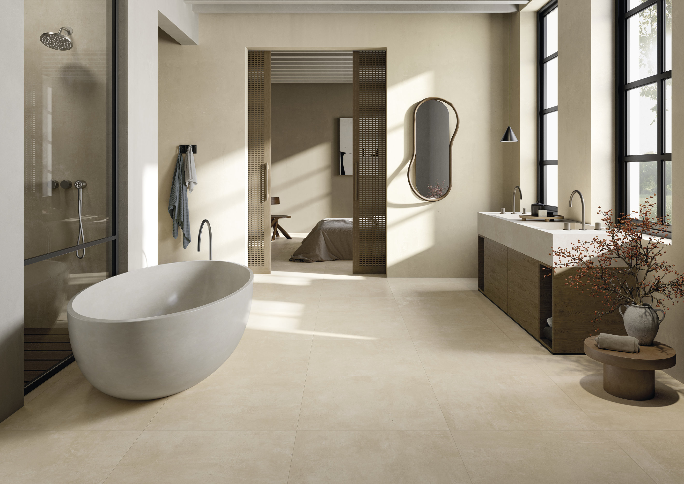 Salle de bain lumineuse et moderne avec carrelage grand format, baignoire îlot et douche.