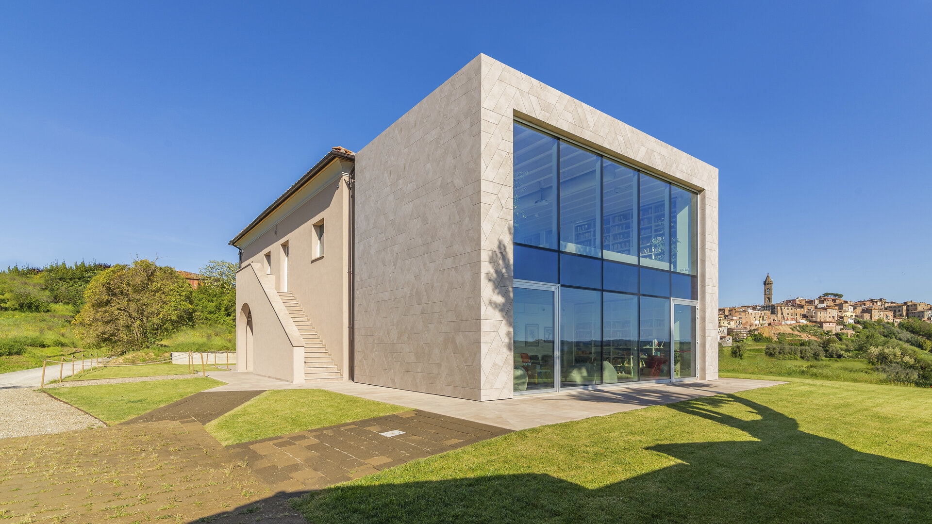 Bâtiment moderne avec façade carrelée claire et grande baie vitrée extérieure.