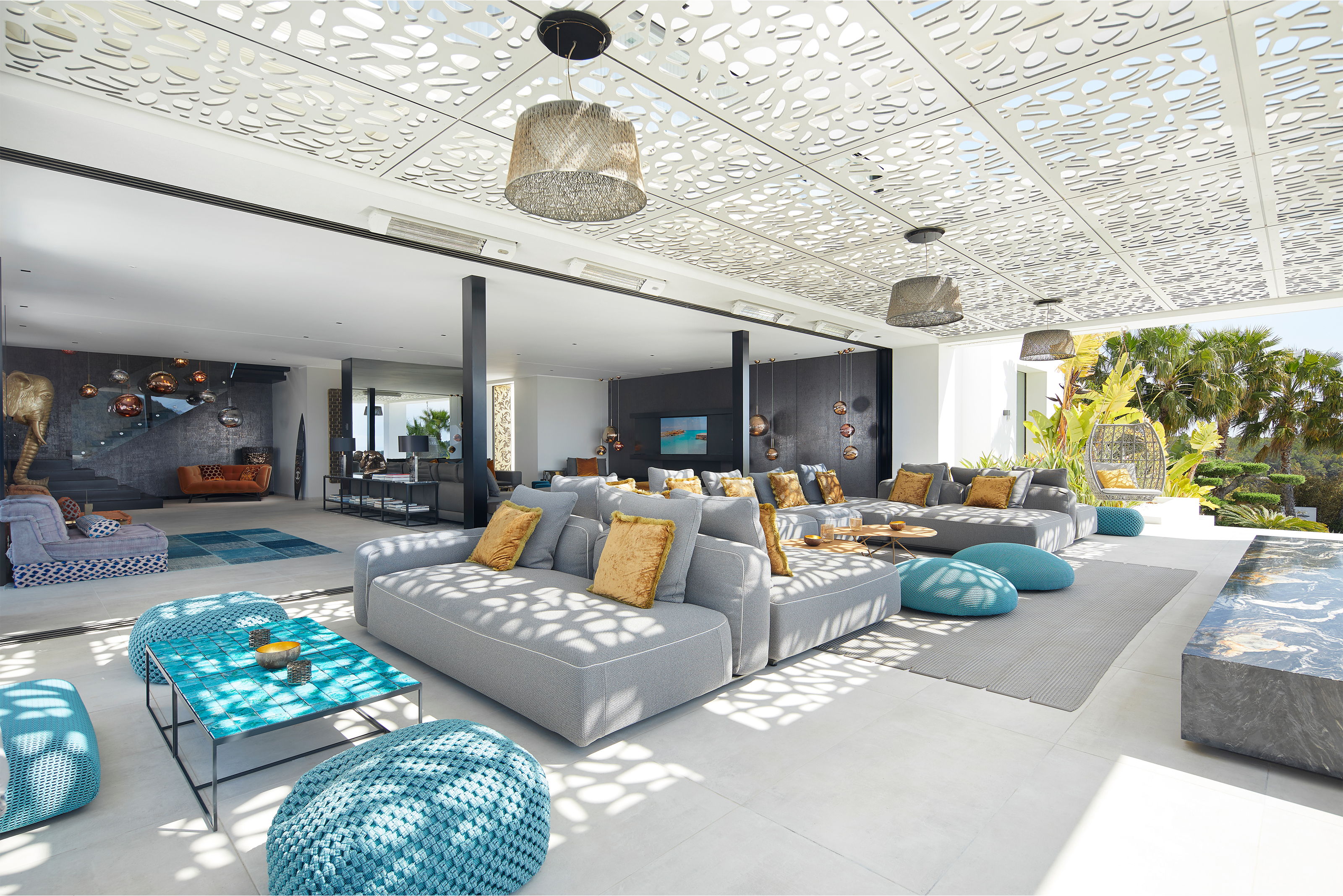 Spacieux espace de vie intérieur-extérieur avec des carreaux clairs et un mobilier élégant.