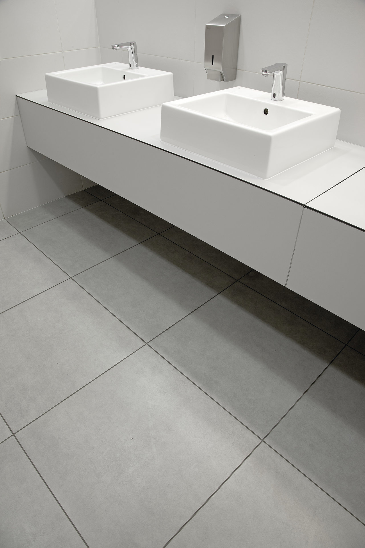 Carreaux modernes gris clair dans la salle de bain sous une double vasque.