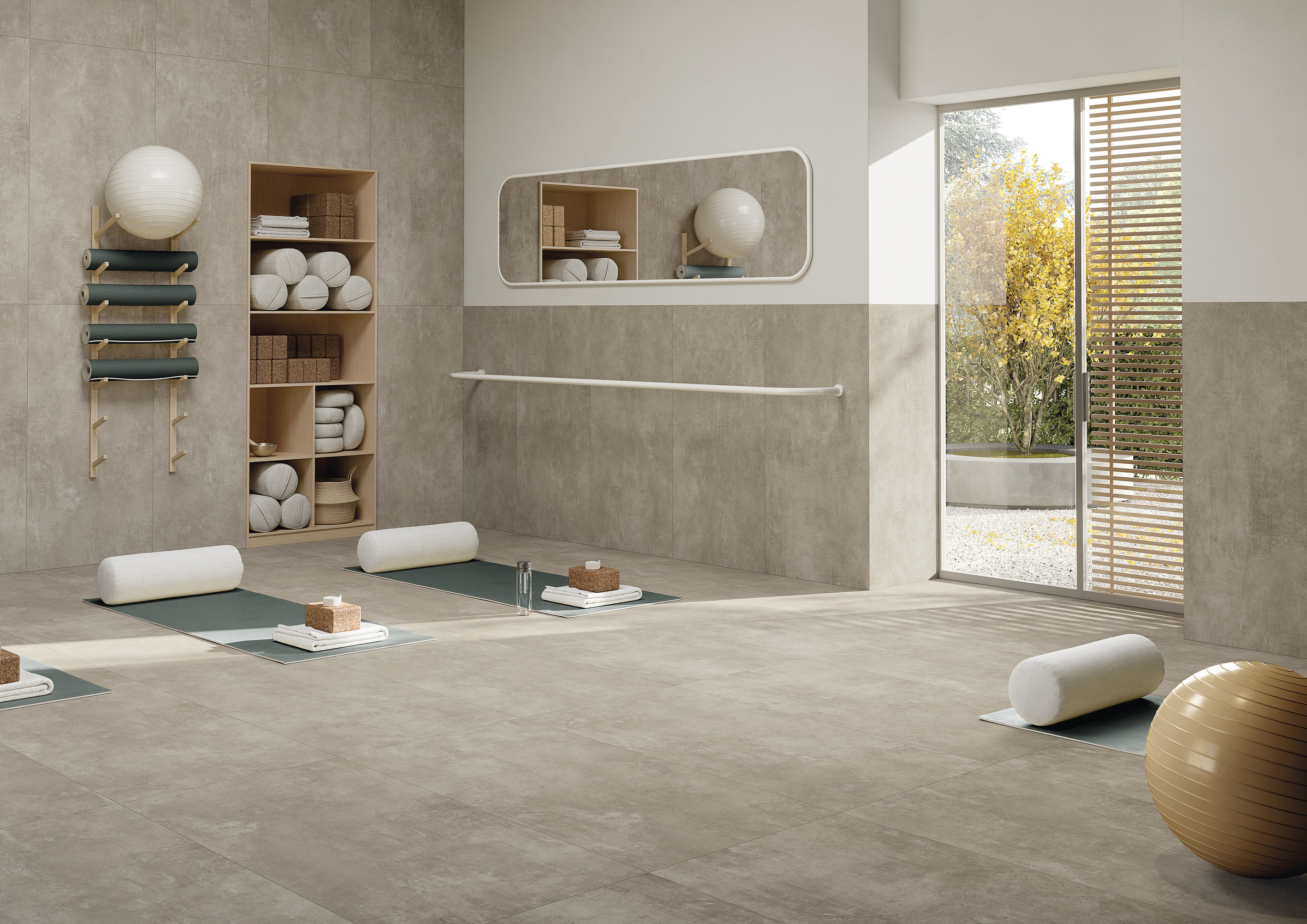 Salle de yoga lumineuse avec carreaux haut de gamme aspect béton sol et murs.