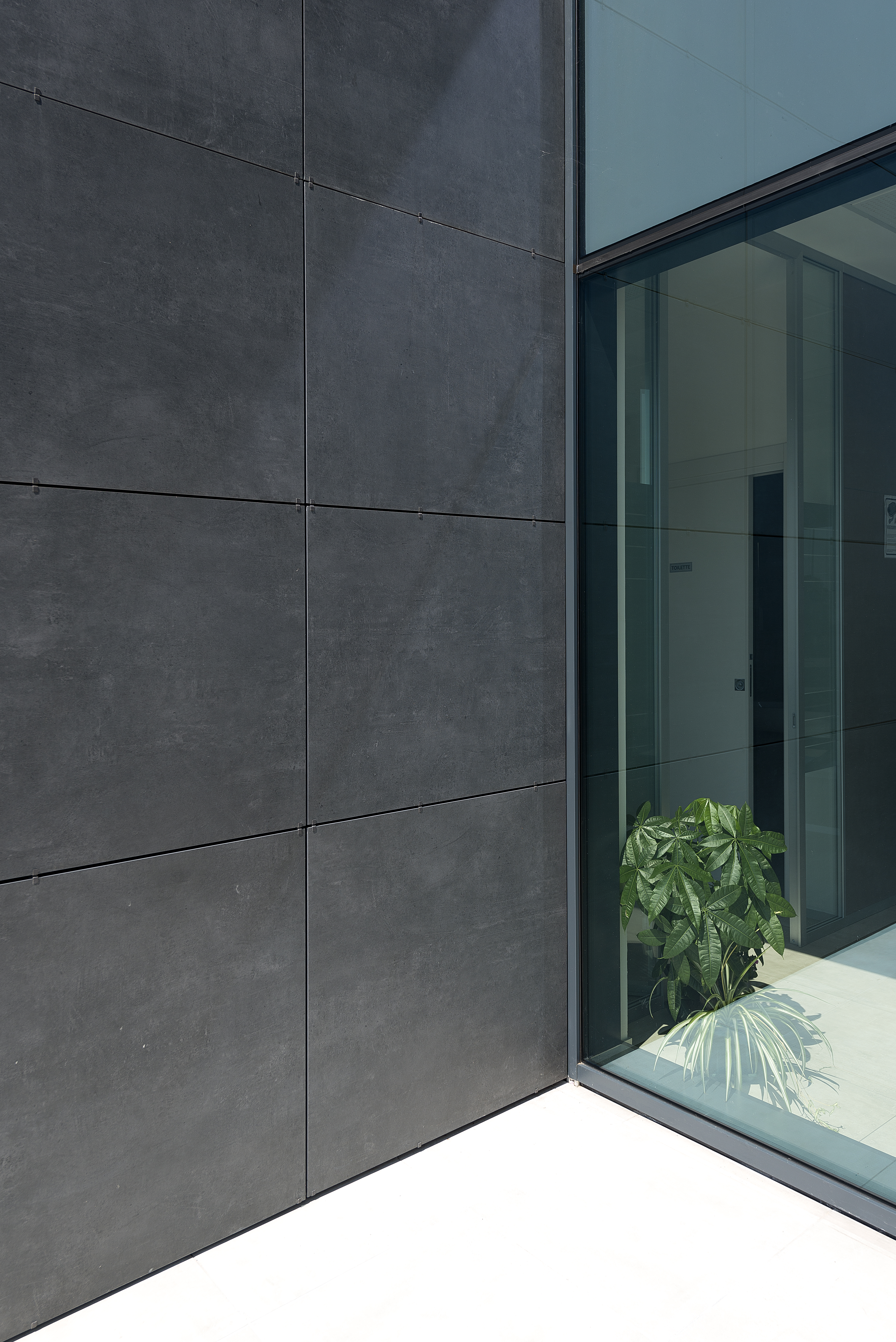Façade moderne avec carreaux extérieurs anthracite et vitrage.