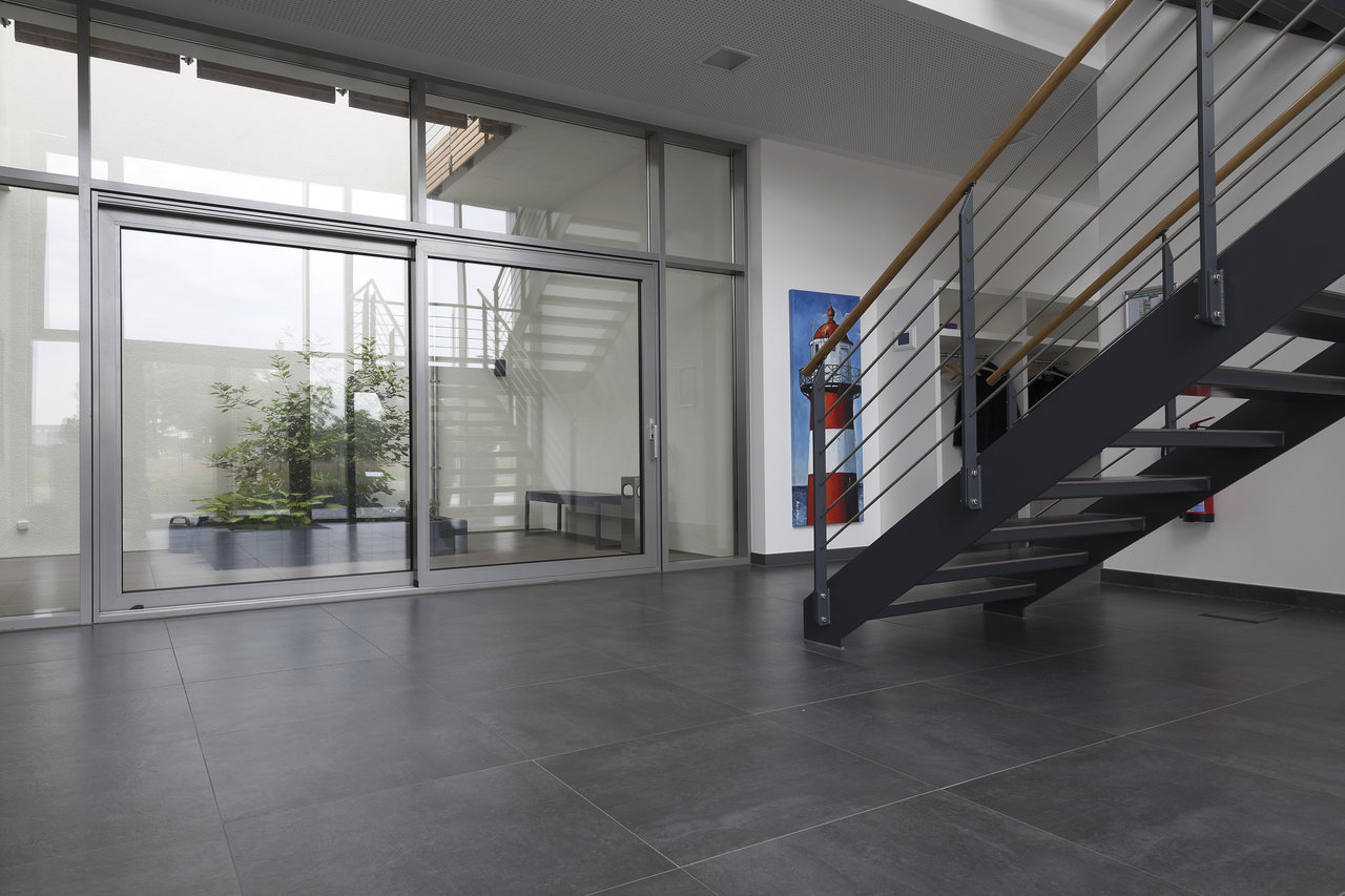 Vaste entrée avec carrelage gris foncé moderne et façade vitrée.