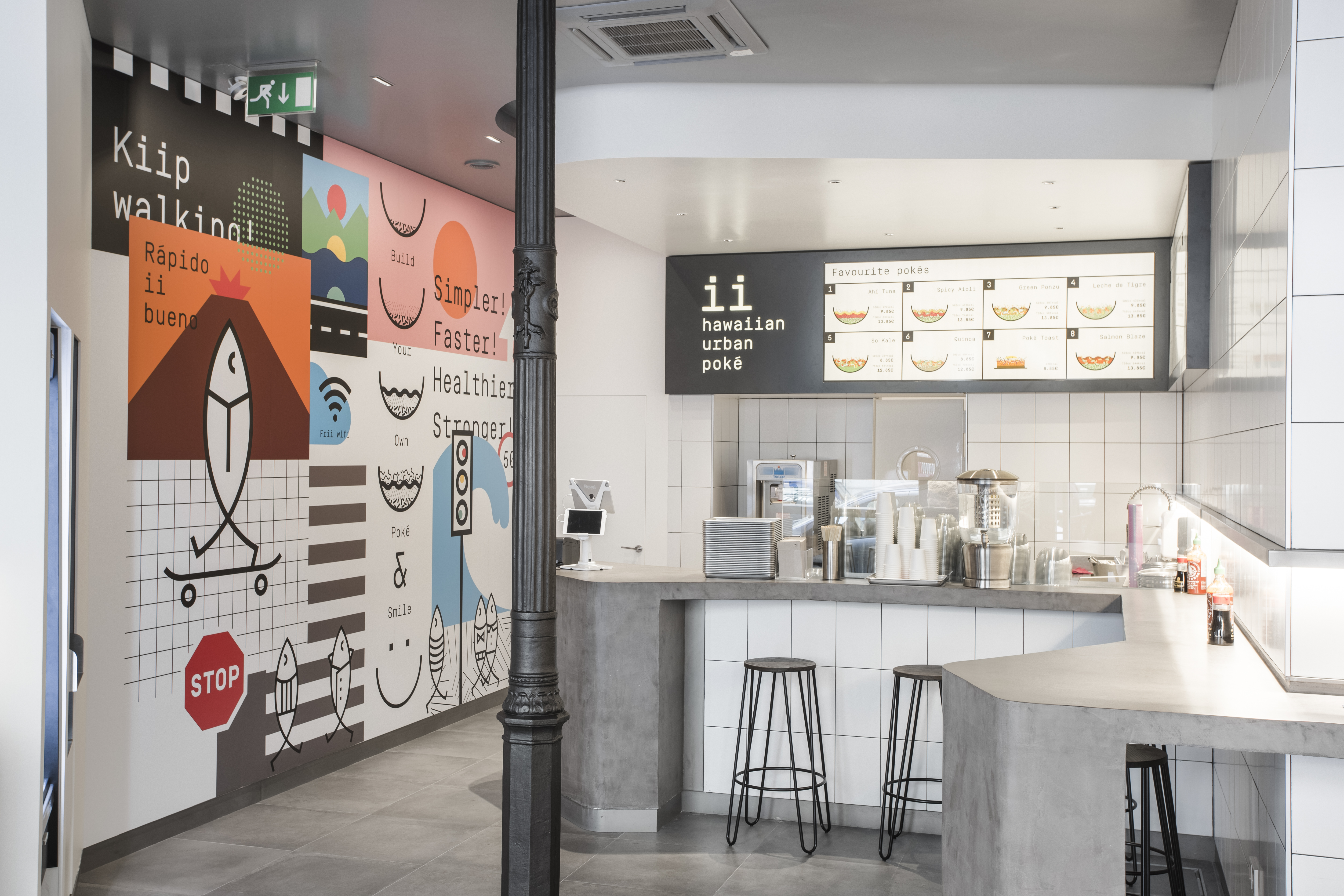 Carreaux de sol modernes effet béton et carreaux muraux blancs dans un restaurant urbain.