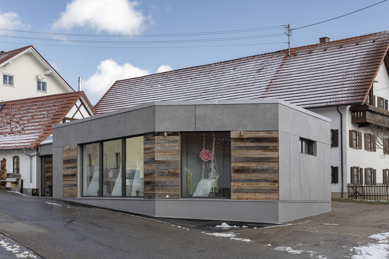 Bâtiment moderne avec façade grise et bardage bois, assorti aux carreaux de haute qualité.