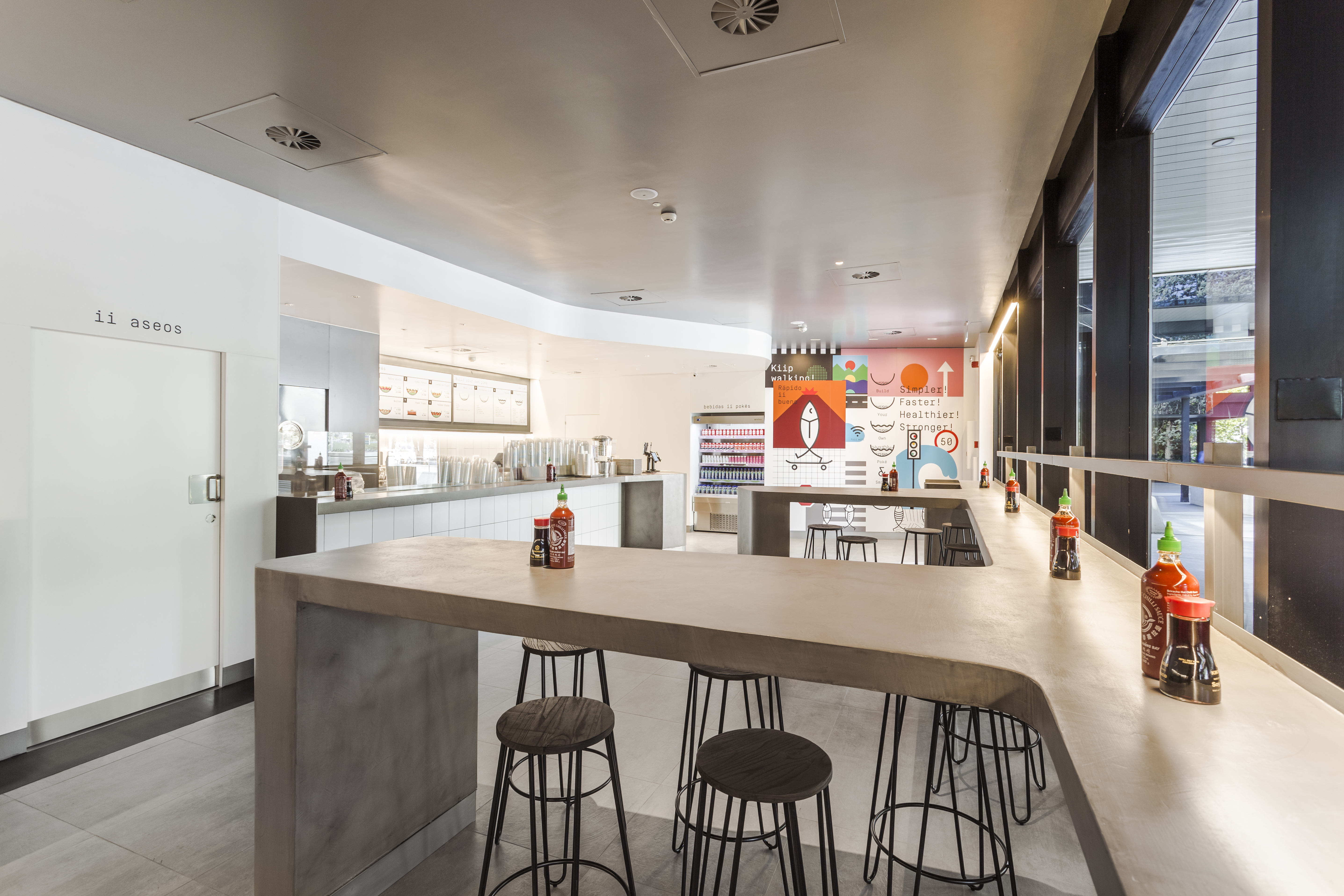 Espace client moderne avec carrelage grand format aspect béton et long comptoir.