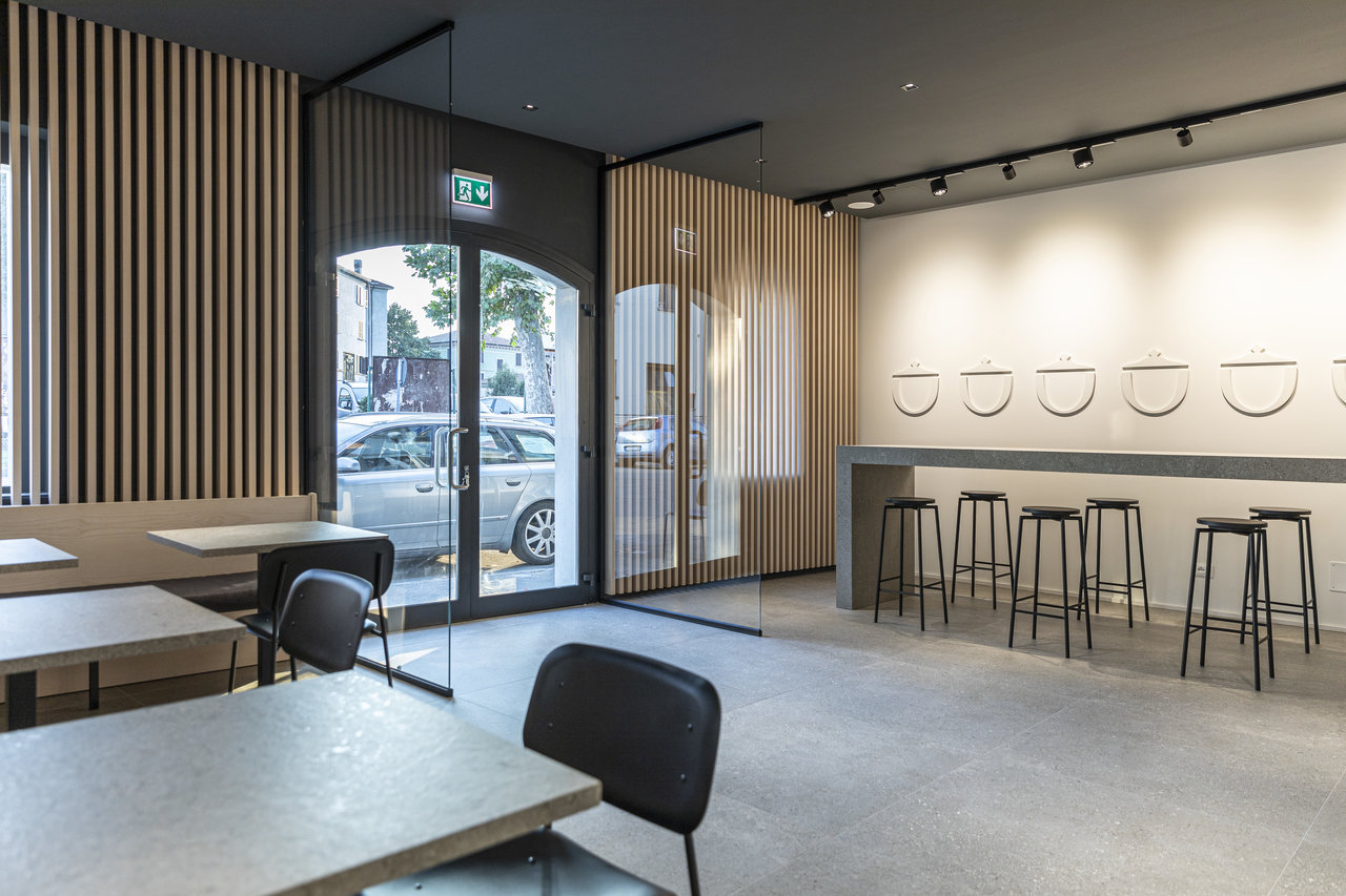 Intérieur élégant avec carrelage grand format effet béton et lamelles de bois.
