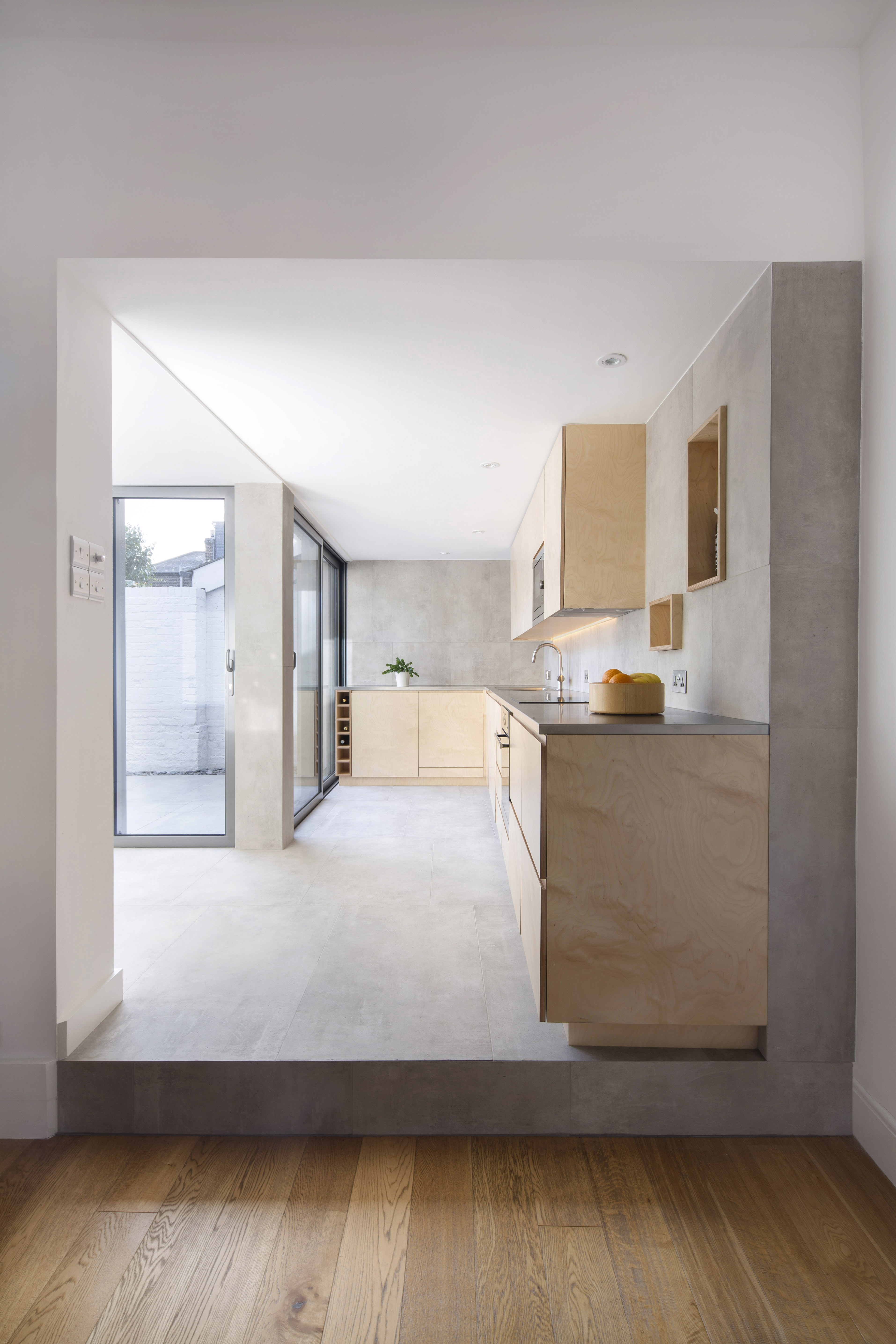 Carreaux aspect béton clair dans une cuisine moderne et sur la terrasse pour une transition harmonieuse.