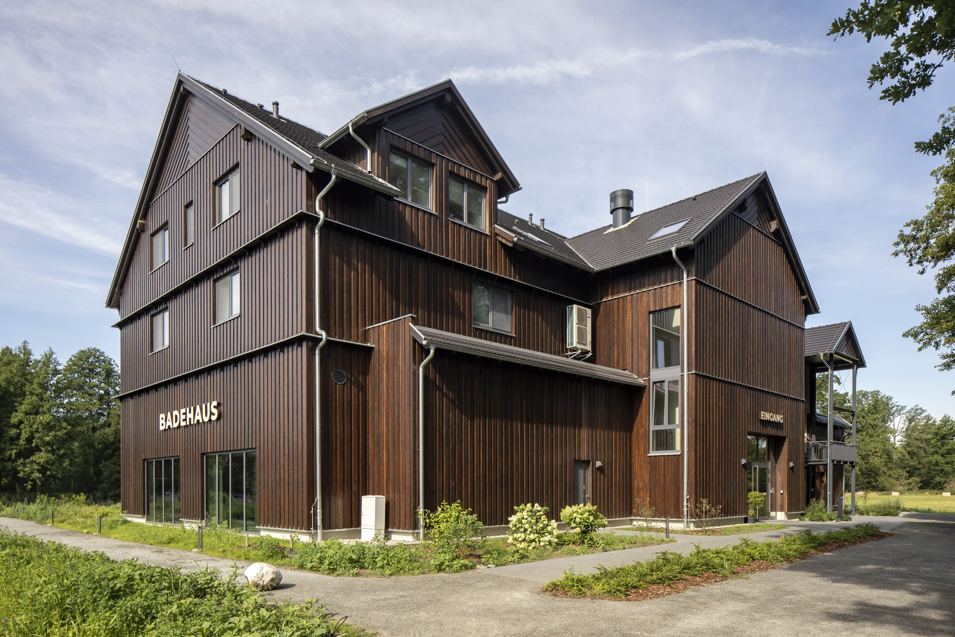 Pavillon de bain moderne avec façade en bois foncé, idéal pour carreaux intérieurs et extérieurs haut de gamme.