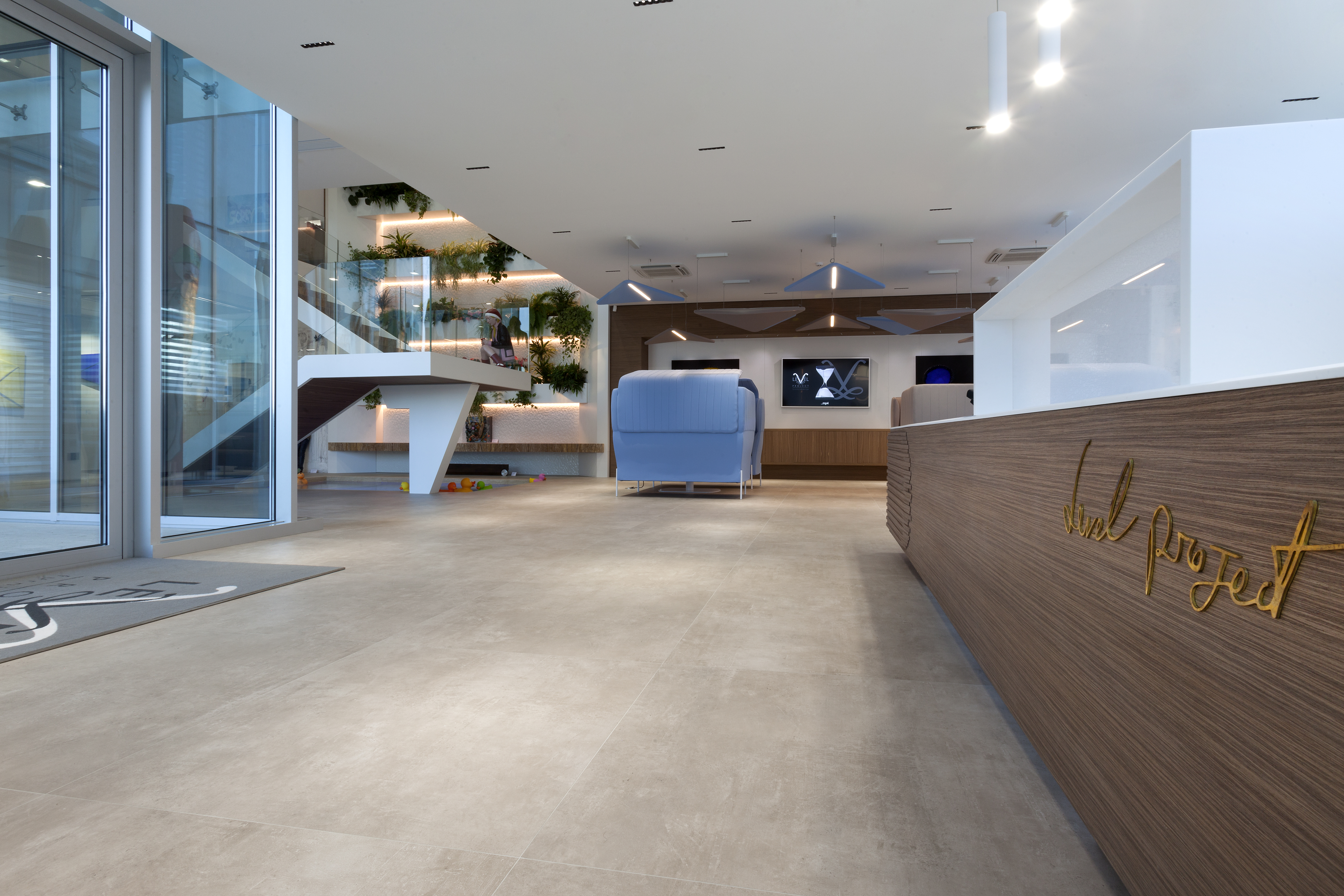 Carreaux de sol clairs grand format pour un hall d'accueil moderne.