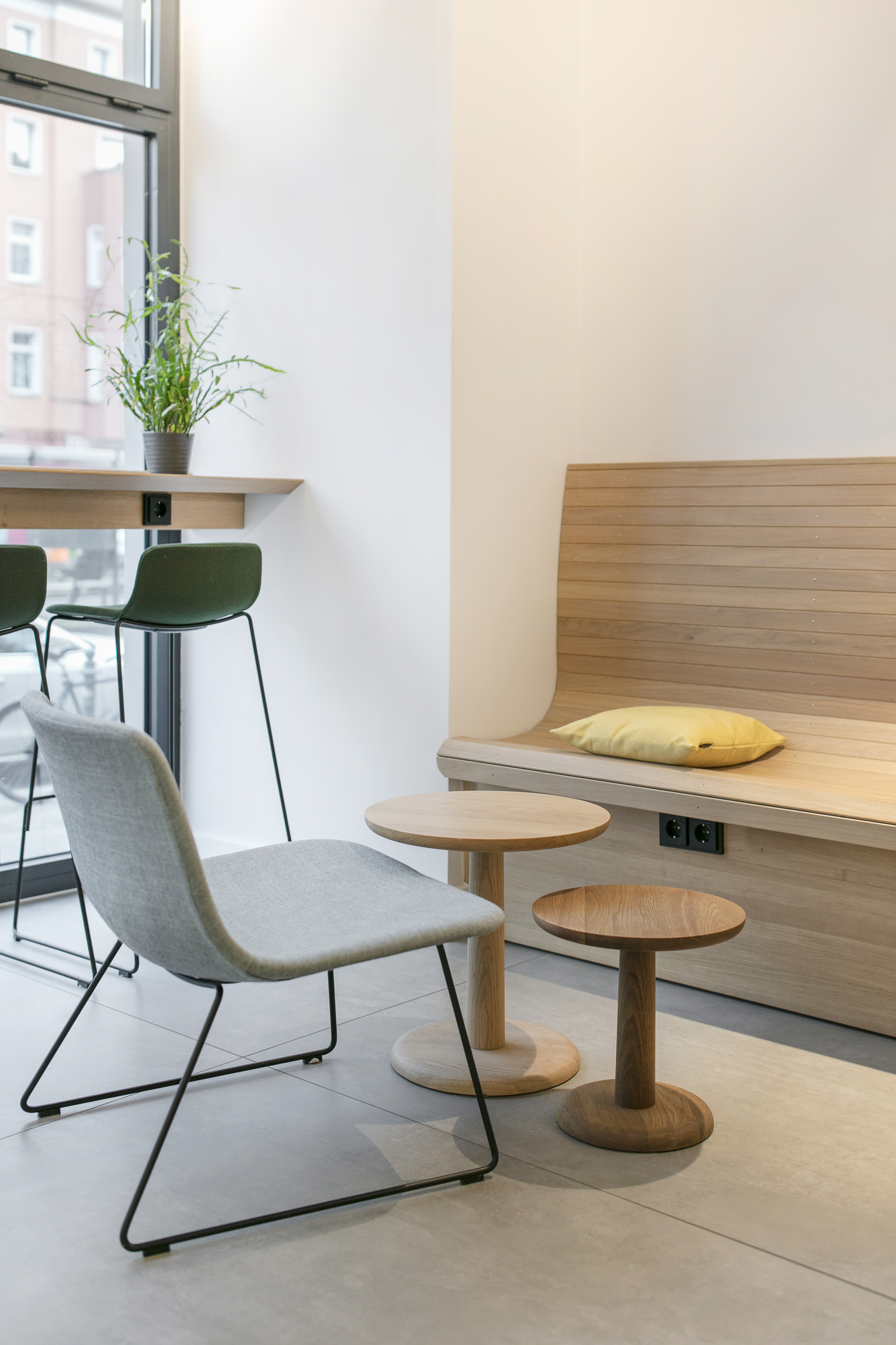 Carreaux clairs haut de gamme dans un espace moderne avec bancs en bois et mobilier design.