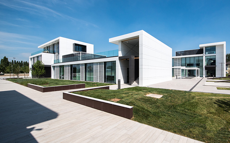 Aménagement extérieur élégant avec grandes dalles claires et bâtiments modernes.