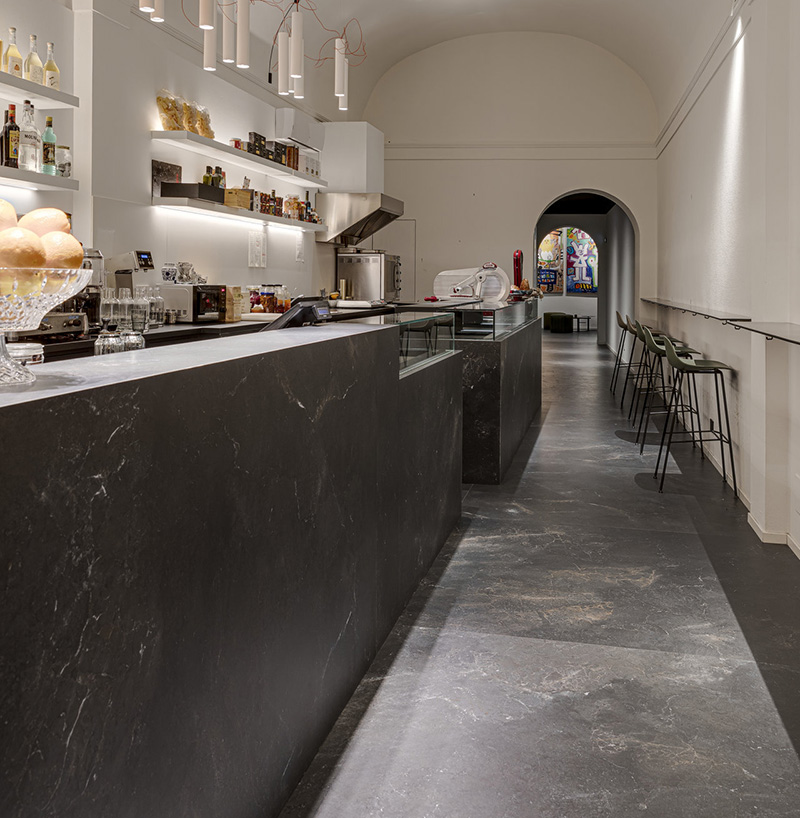 Grandes dalles gris foncé aspect pierre pour sol et comptoir de café.