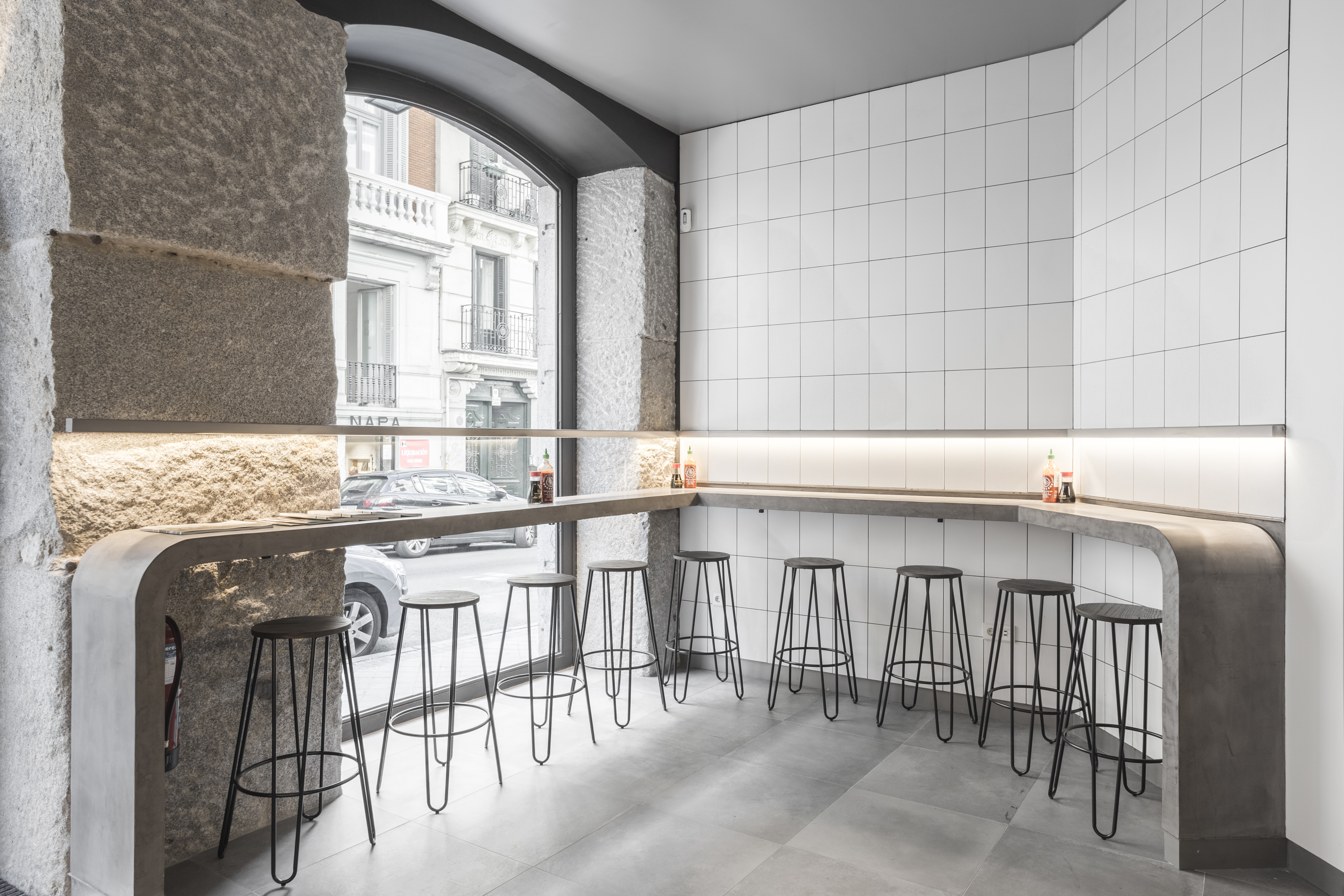 Intérieur minimaliste avec carreaux muraux blancs et carreaux grand format gris au sol.