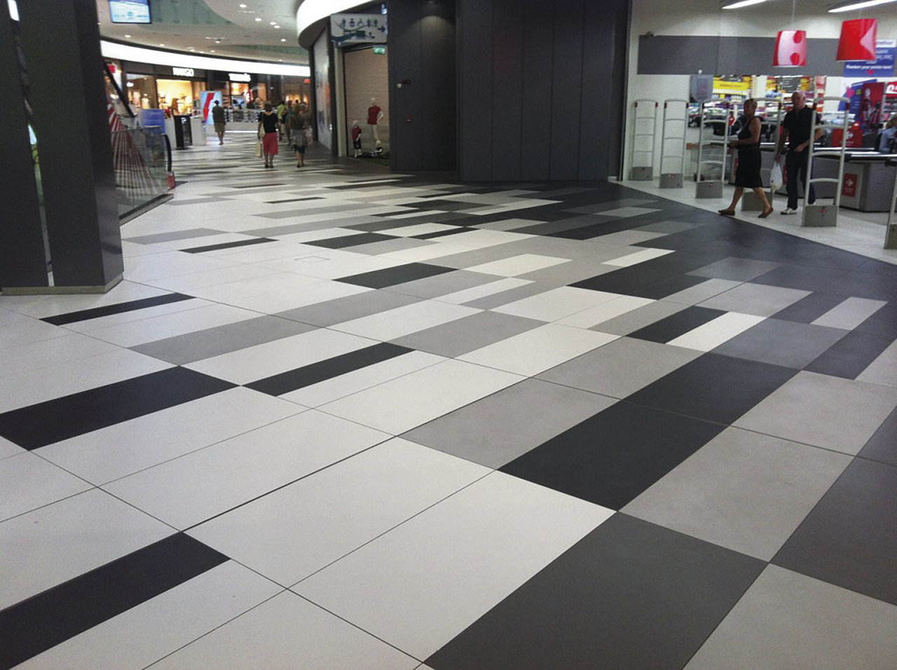 Carrelage moderne gris, noir et blanc à motif géométrique.