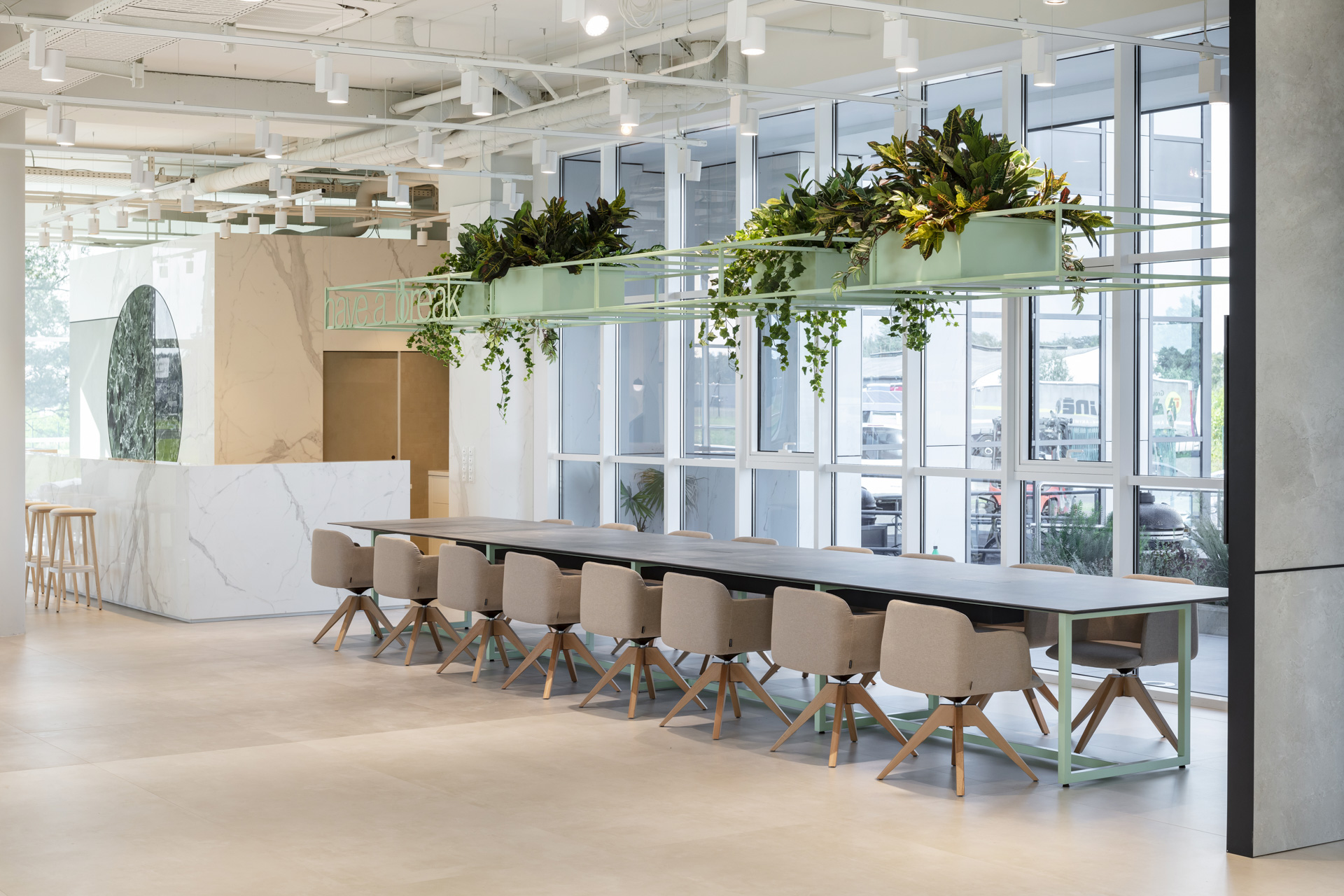 Moderne, lumineuse pièce avec carrelage de sol haut de gamme, table de conférence et touches végétales.