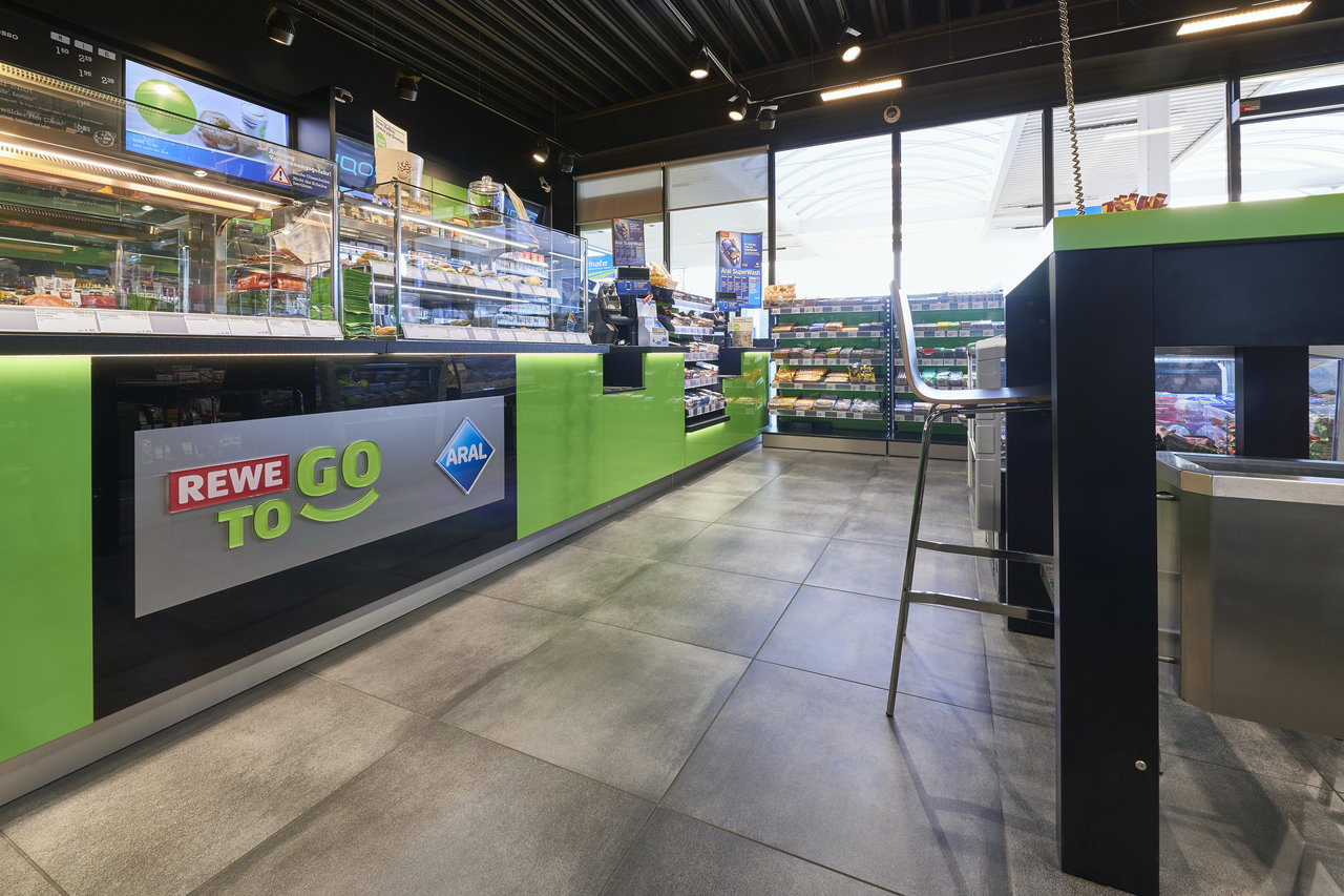 Grandes dalles de sol grises robustes en intérieur (ex: REWE To Go).