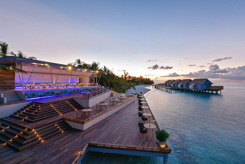 Terrasse luxueuse en bord de mer au coucher du soleil, idéale pour carrelage extérieur haut de gamme.