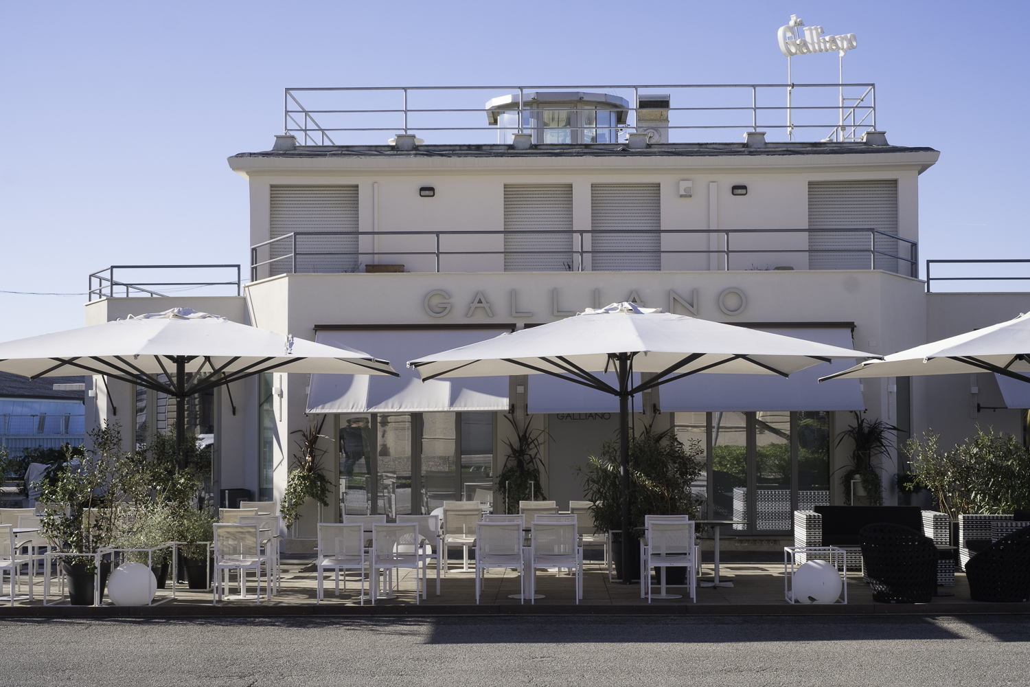 Terrasse extérieure moderne avec mobilier blanc et parasols, parfaite pour des carreaux d'extérieur de haute qualité.