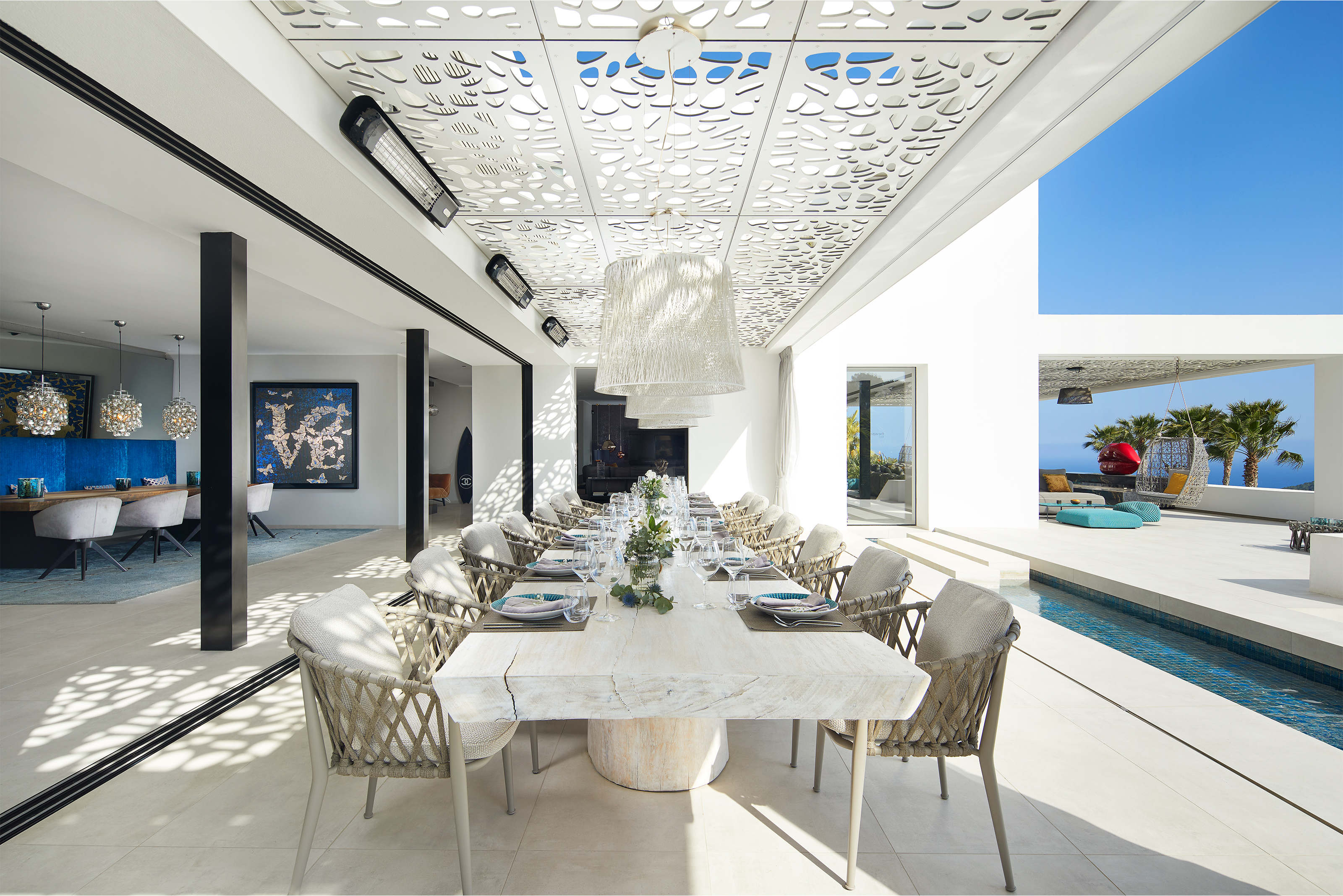 Espace repas moderne avec carreaux haut de gamme, design ouvert et accès piscine.