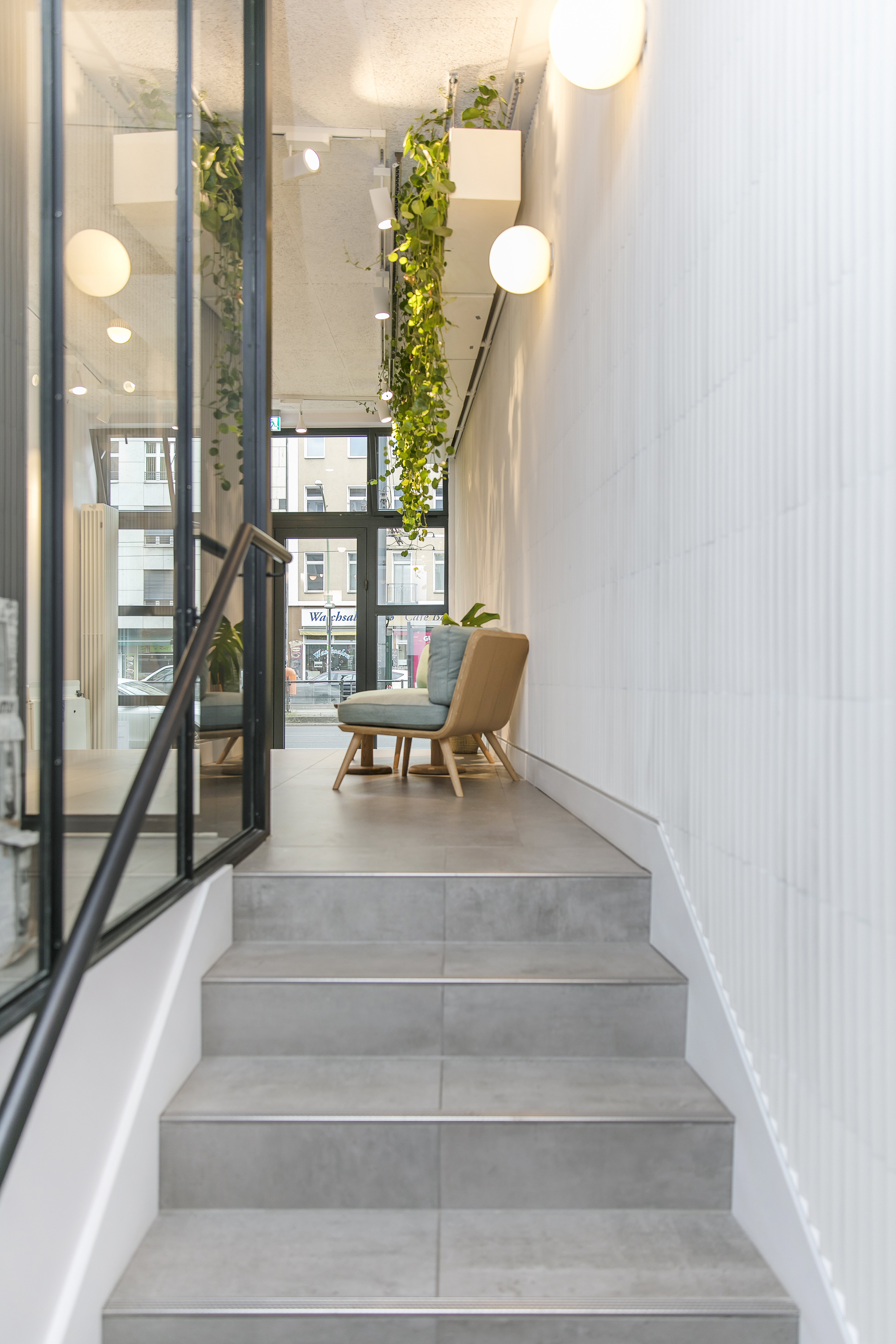 Carreaux de sol et d'escalier gris modernes, combinés à des carreaux muraux blancs texturés.