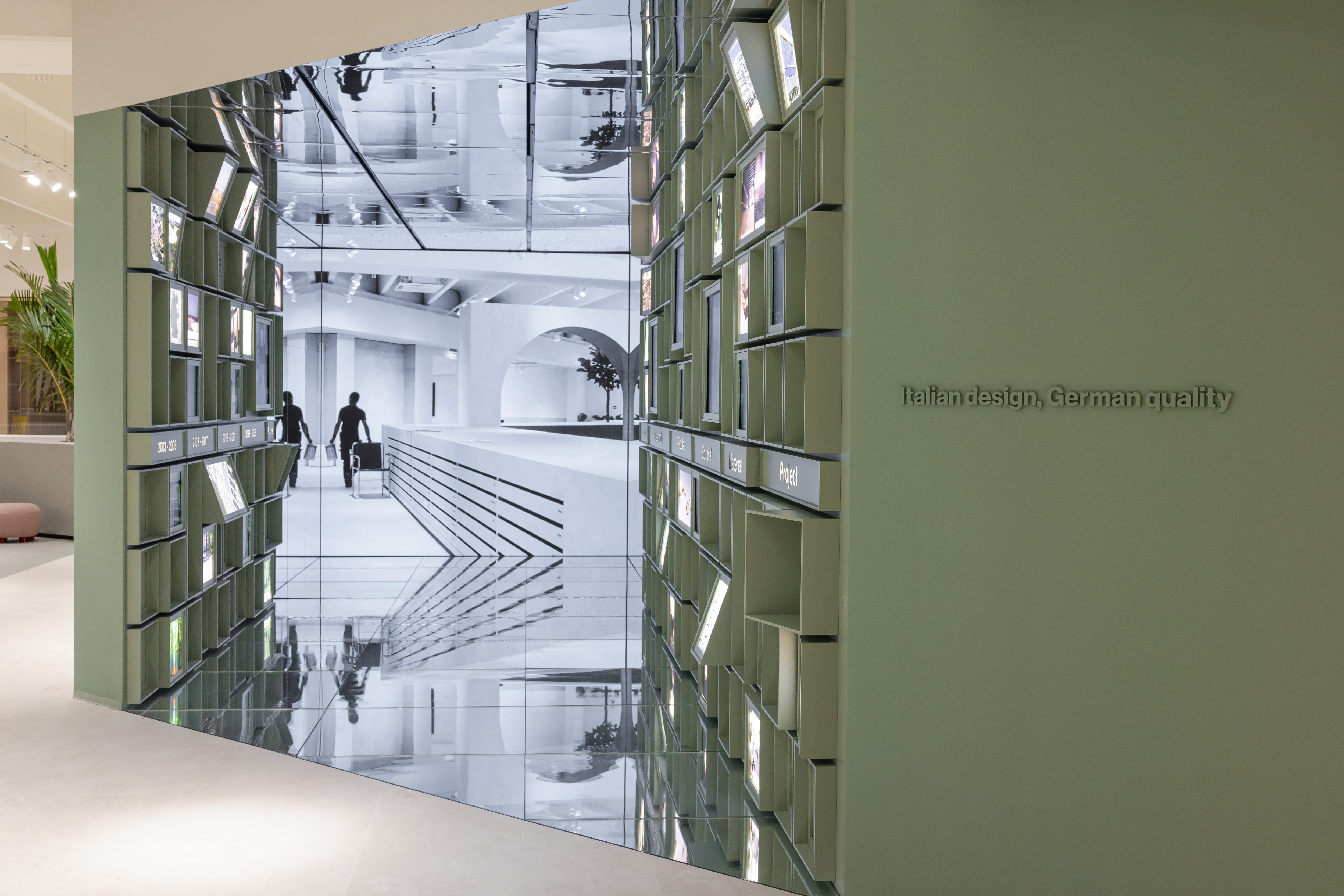 Showroom de carrelage : Présentation moderne avec écran numérique et 'Design italien, qualité allemande'.