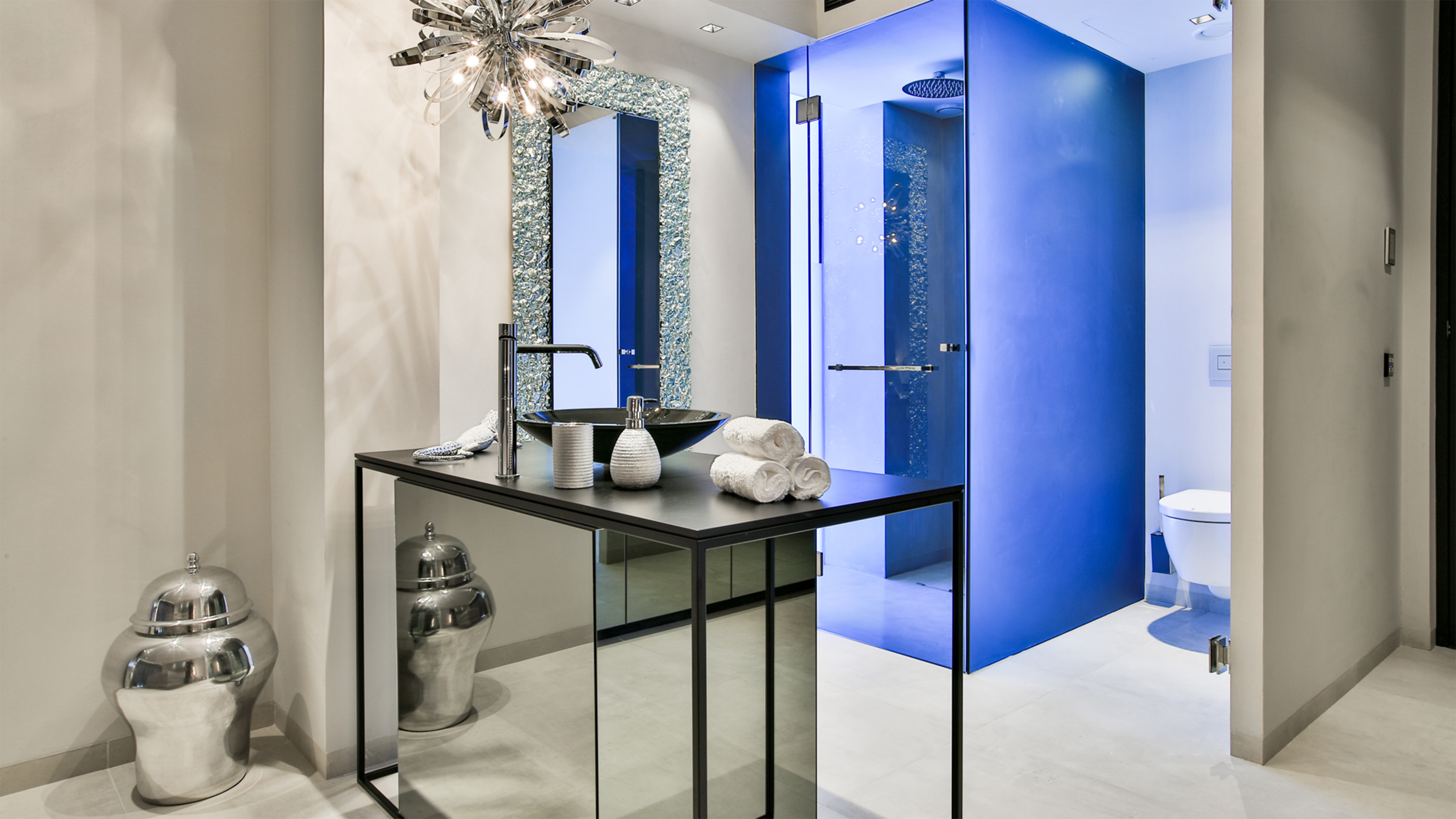 Carreaux de sol clairs dans une salle de bain luxueuse avec une paroi de douche bleue.