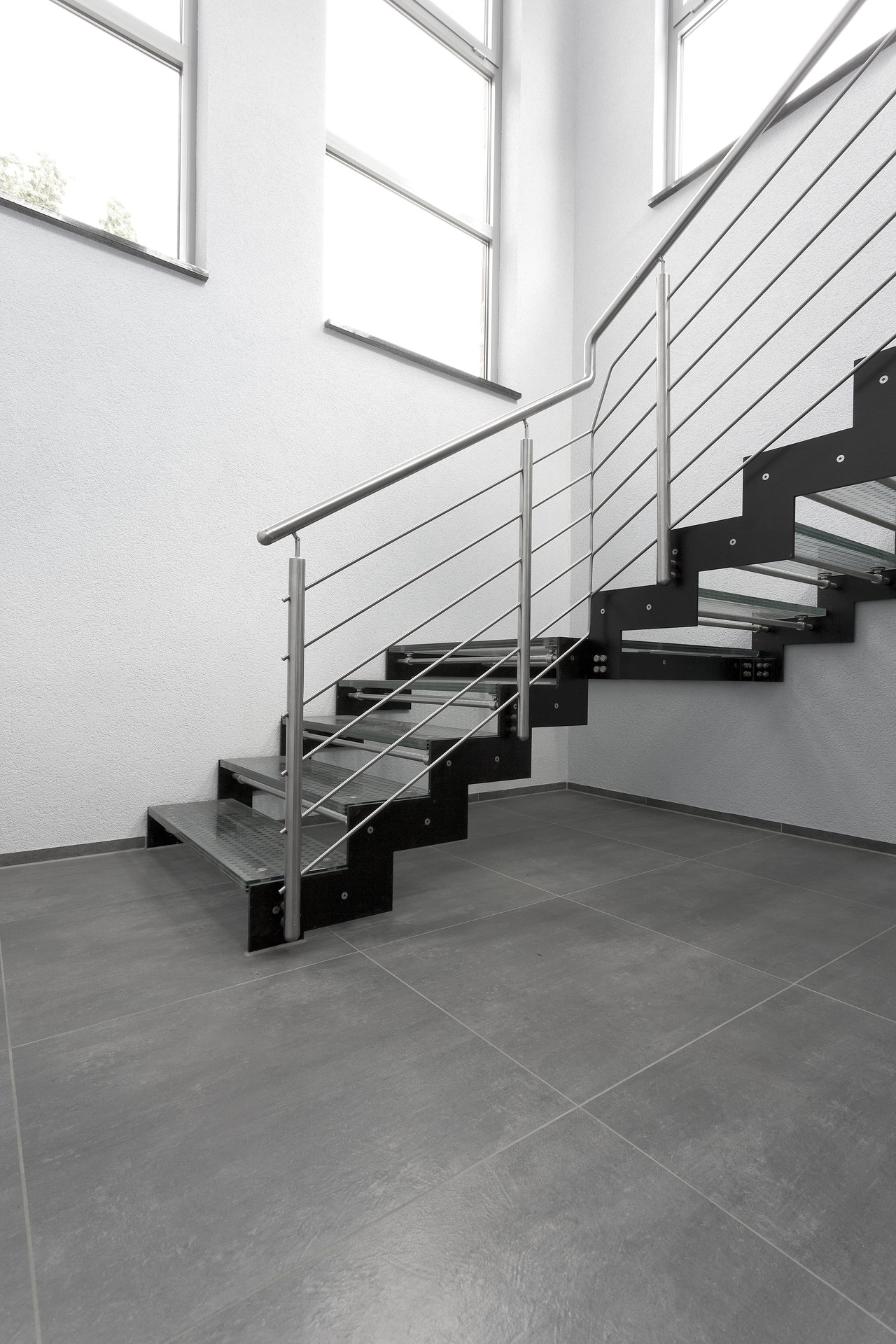 Carreaux gris grand format dans un escalier moderne.