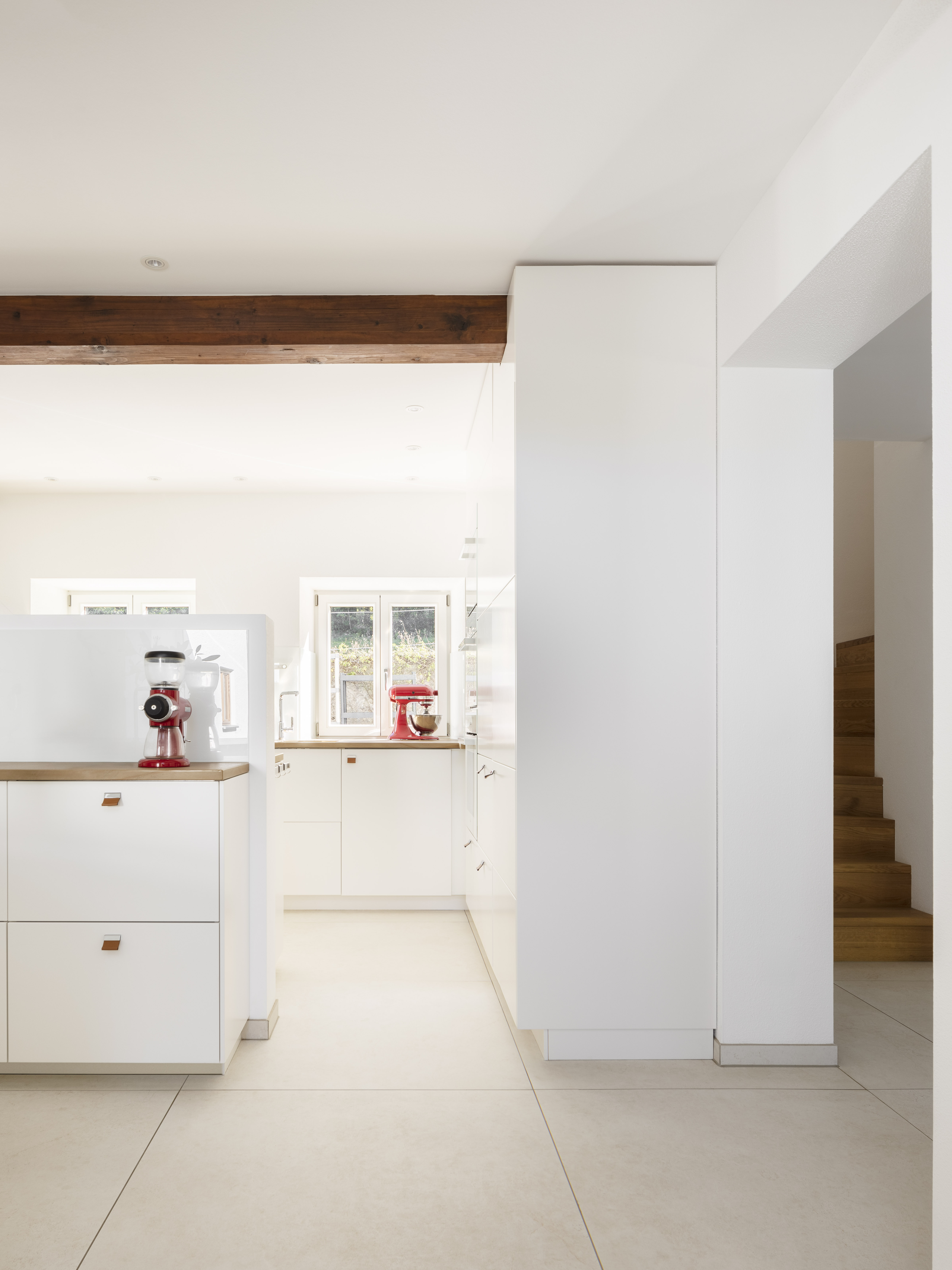 Carrelage de sol clair dans une cuisine moderne et ouverte avec des touches de bois.