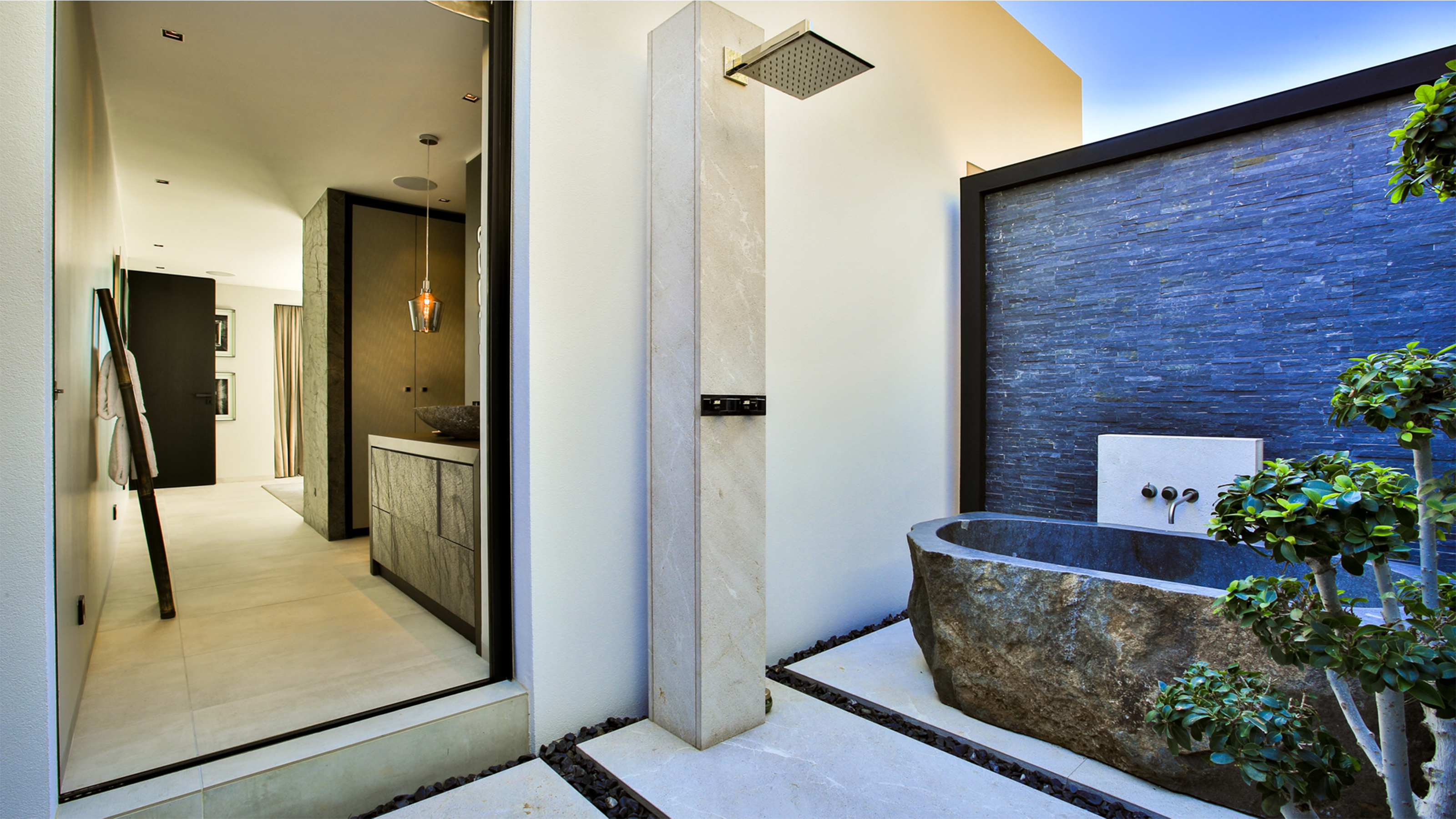 Espace extérieur élégant avec douche, baignoire en pierre naturelle et carreaux Porcelaingres d'extérieur de qualité supérieure.