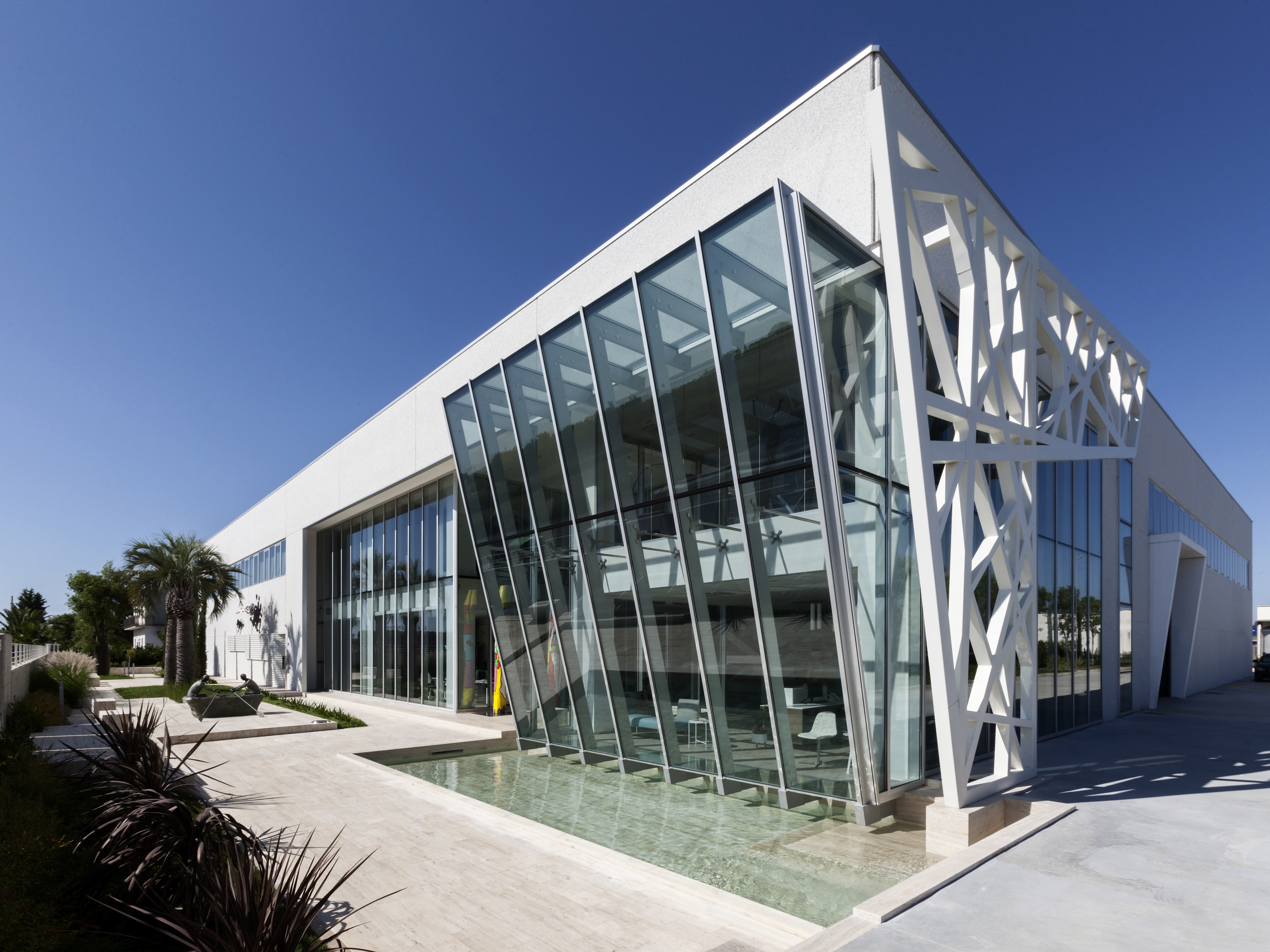 Bâtiment élégant et moderne avec façade en verre et eau, reflétant le style de nos carreaux.