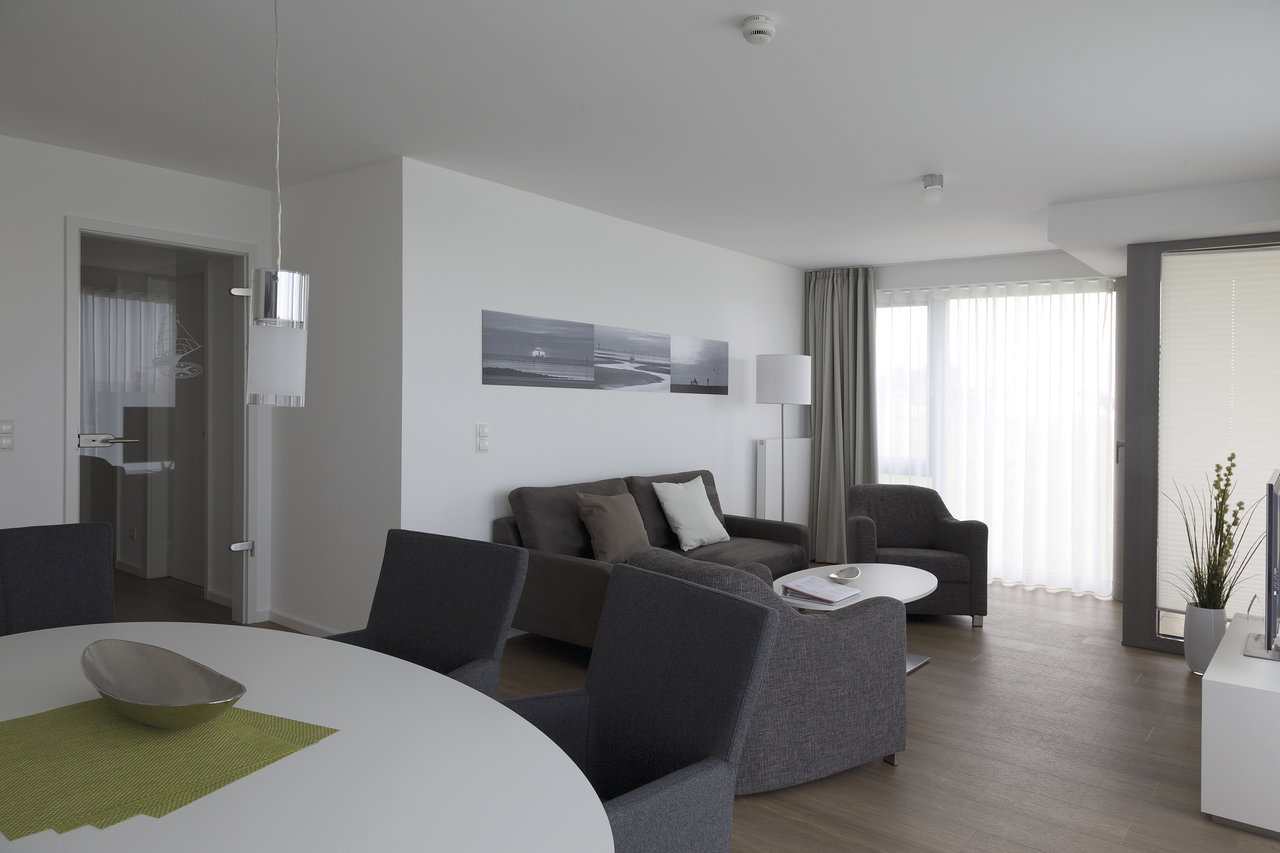 Salon lumineux avec carrelage moderne aspect bois chaleureux.