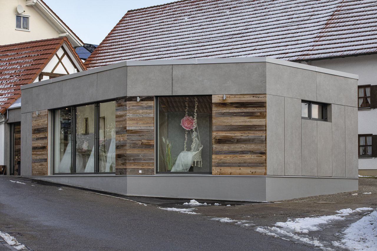 Façade moderne avec grandes dalles grises et boiseries.