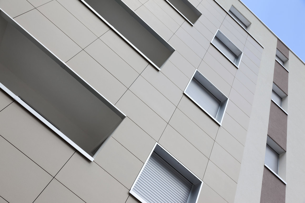 Façade de bâtiment avec des carreaux extérieurs clairs et grand format.