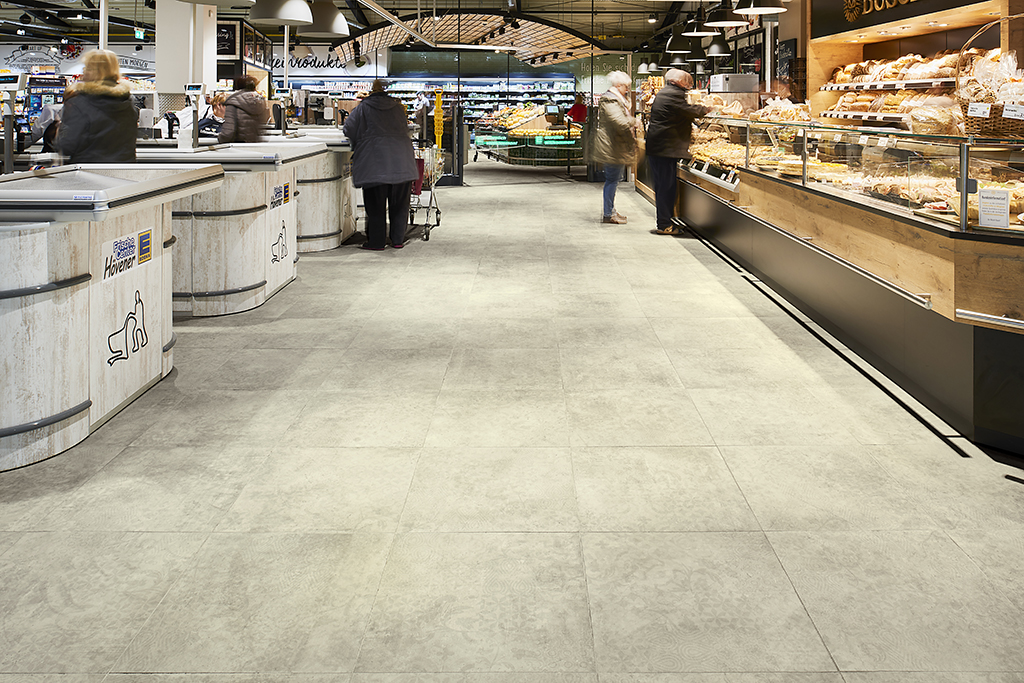 Carreaux gris clair robustes, parfaits pour intérieurs commerciaux (ex: supermarchés).