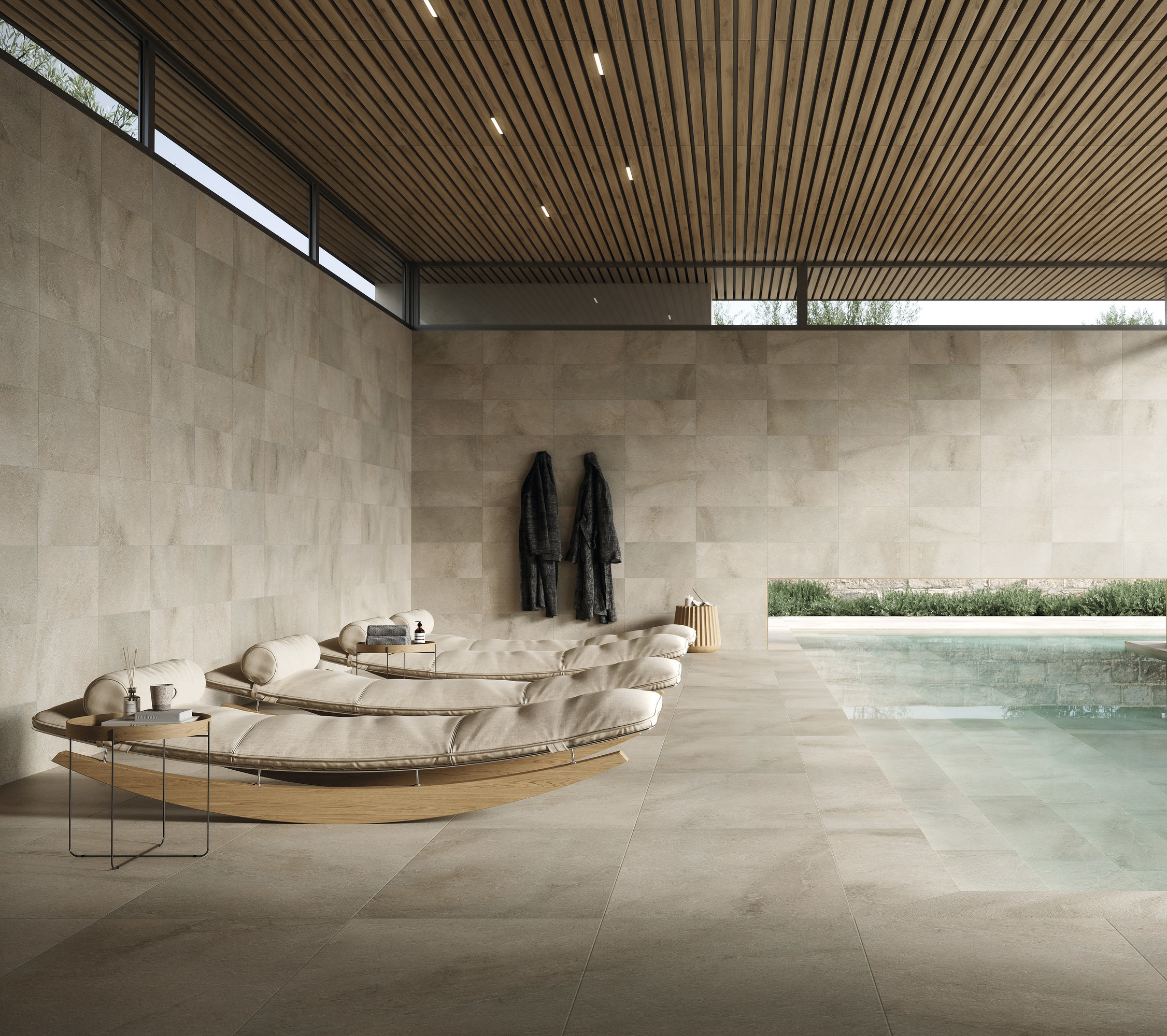 Espace bien-être exclusif avec carrelage en porcelaine clair au sol et aux murs, piscine et transats.