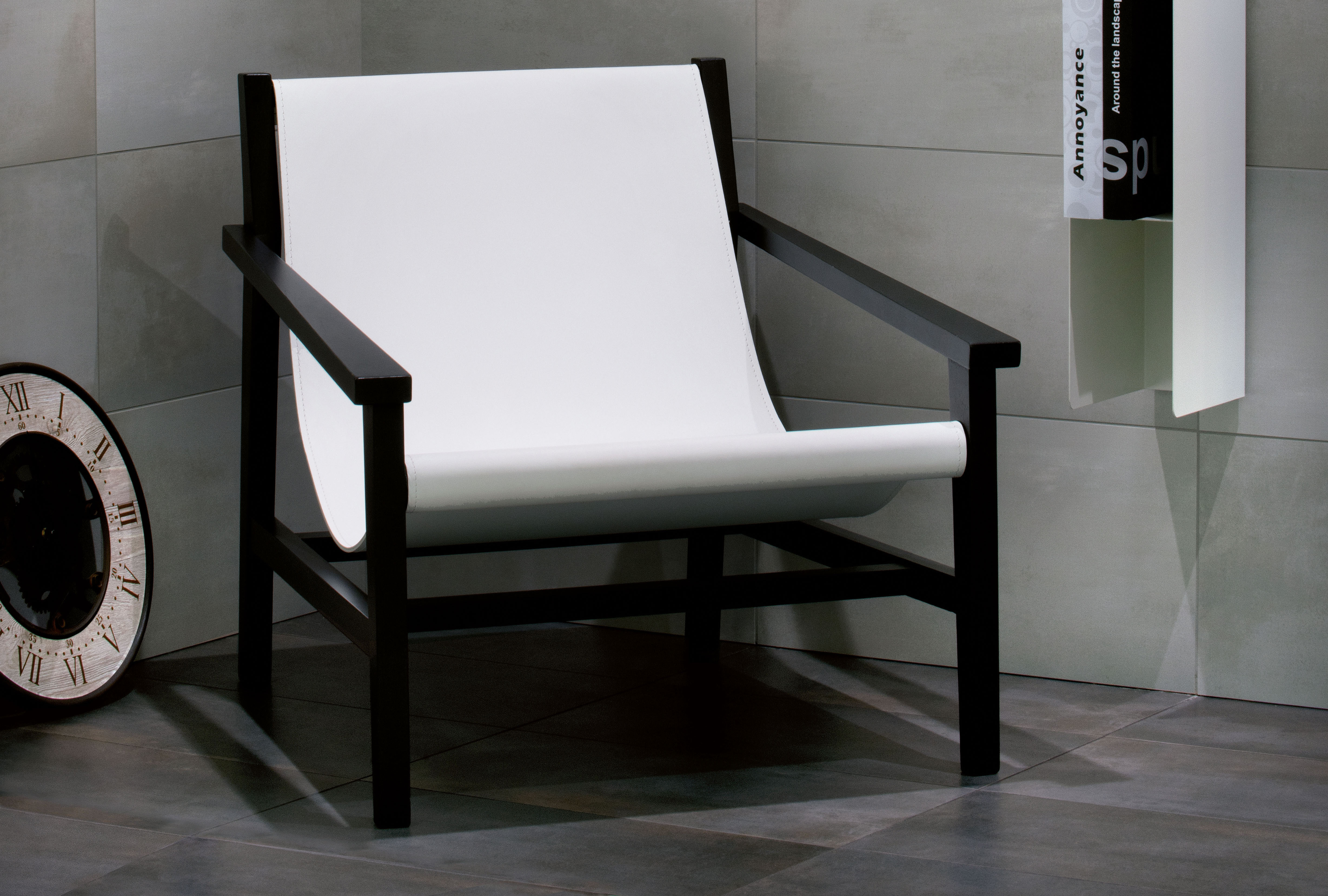 Stilvolles Wohnzimmer mit grauen Porcelaingres Fliesen und modernem Sessel.