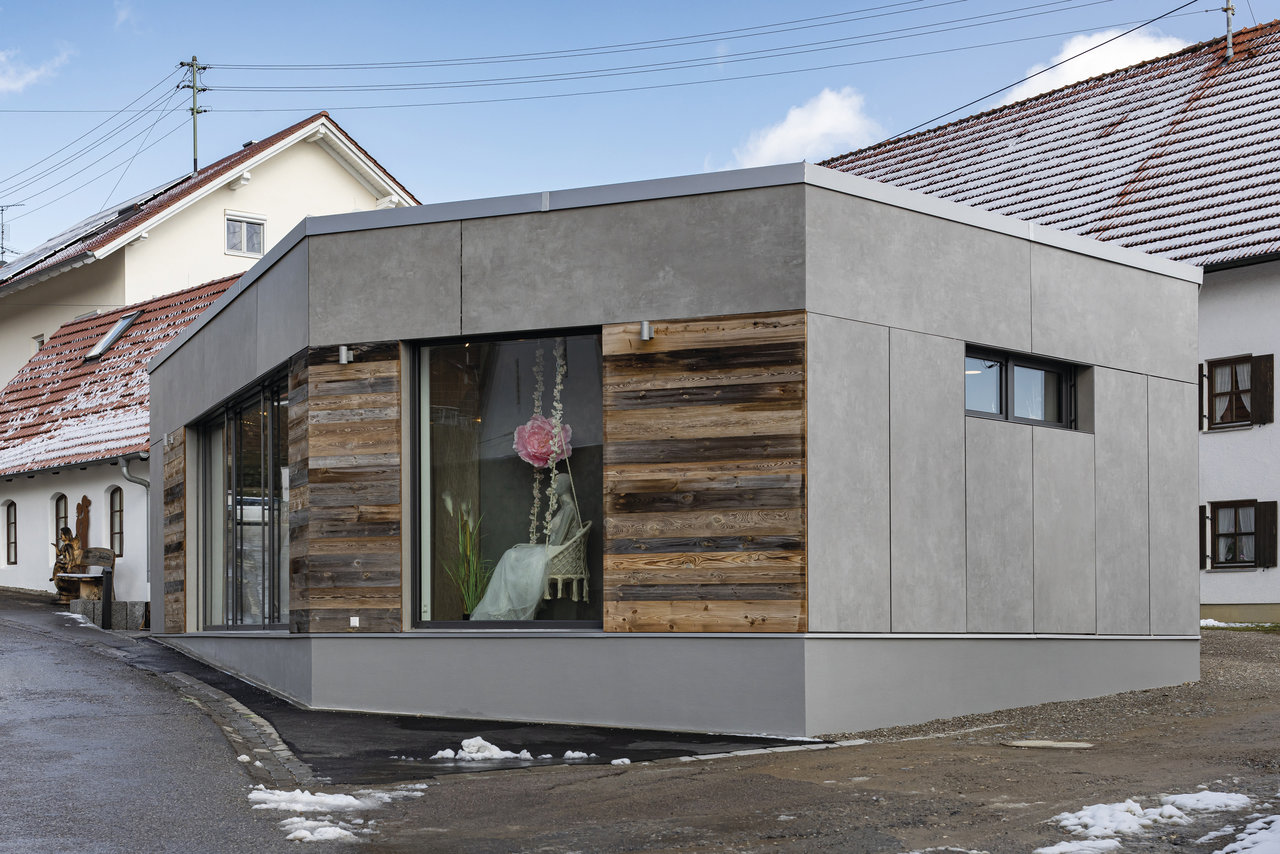 Façade moderne avec dalles grises effet béton et revêtement bois.