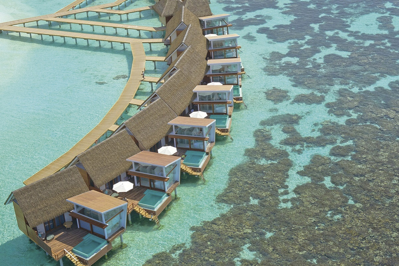Vue aérienne d'un resort de luxe sur pilotis, source d'inspiration pour carrelage extérieur chic.
