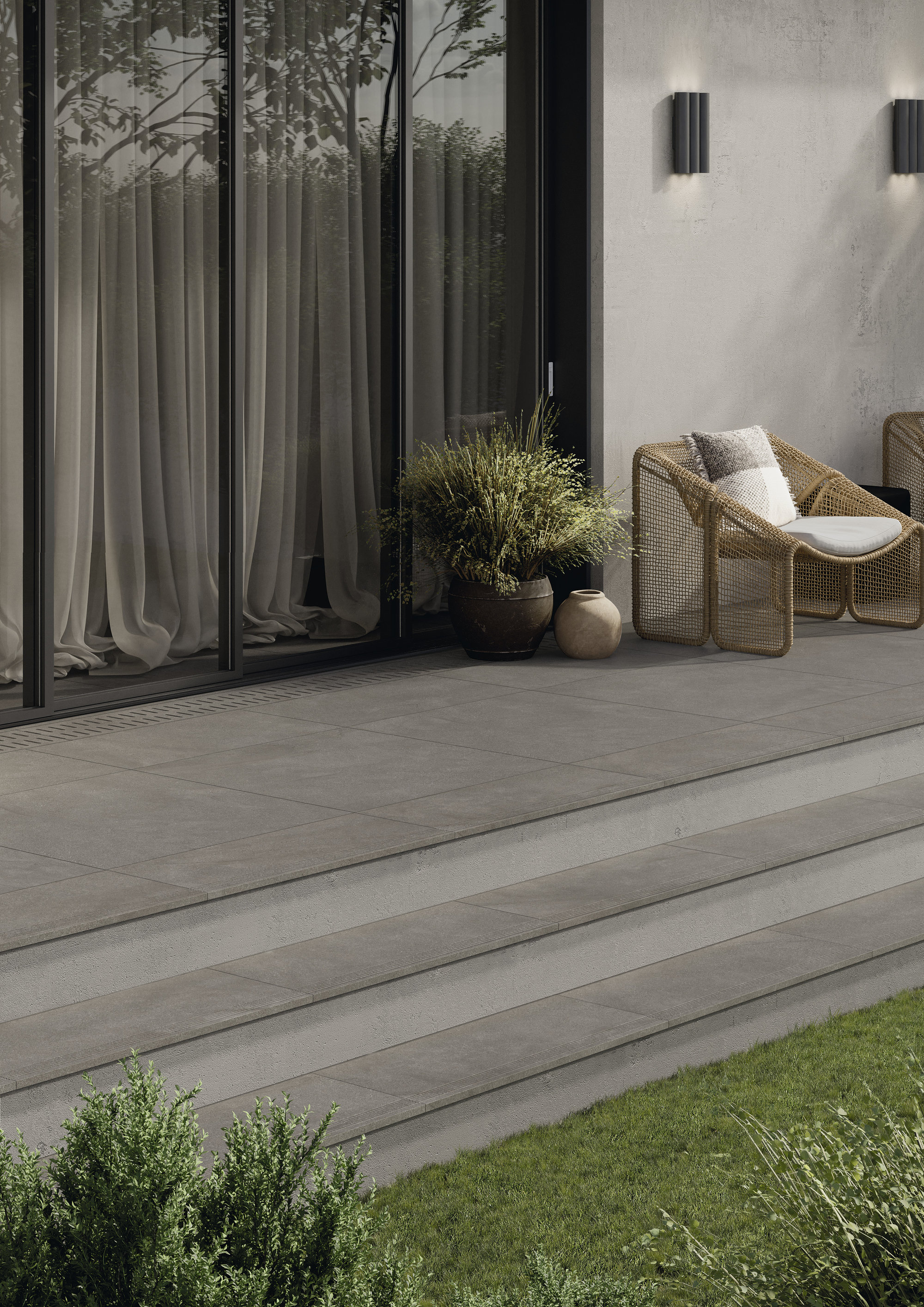 Carreaux d'extérieur gris de qualité supérieure sur terrasse moderne avec marches vers le jardin.