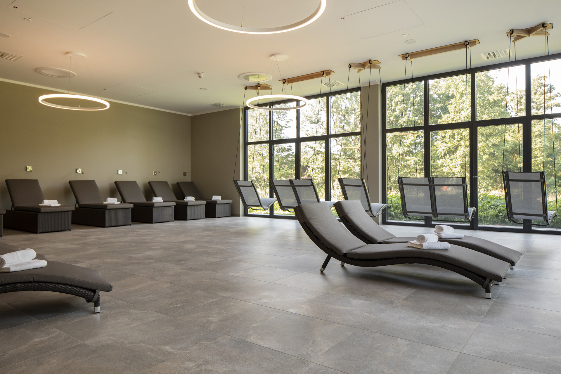 Élégant espace bien-être avec carrelage de sol gris grand format et chaises longues.
