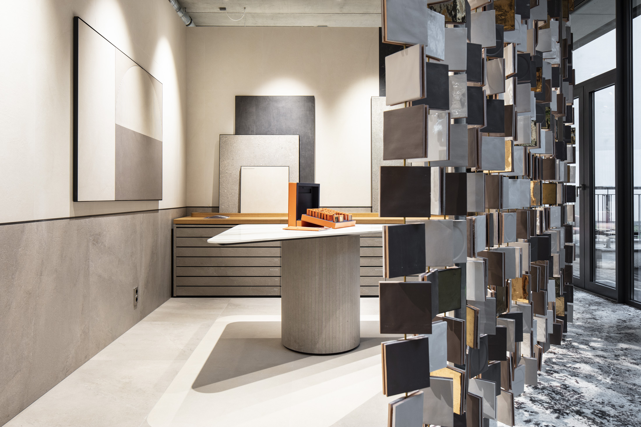 Showroom moderne avec divers motifs de carreaux et une cloison décorative en carrelage.