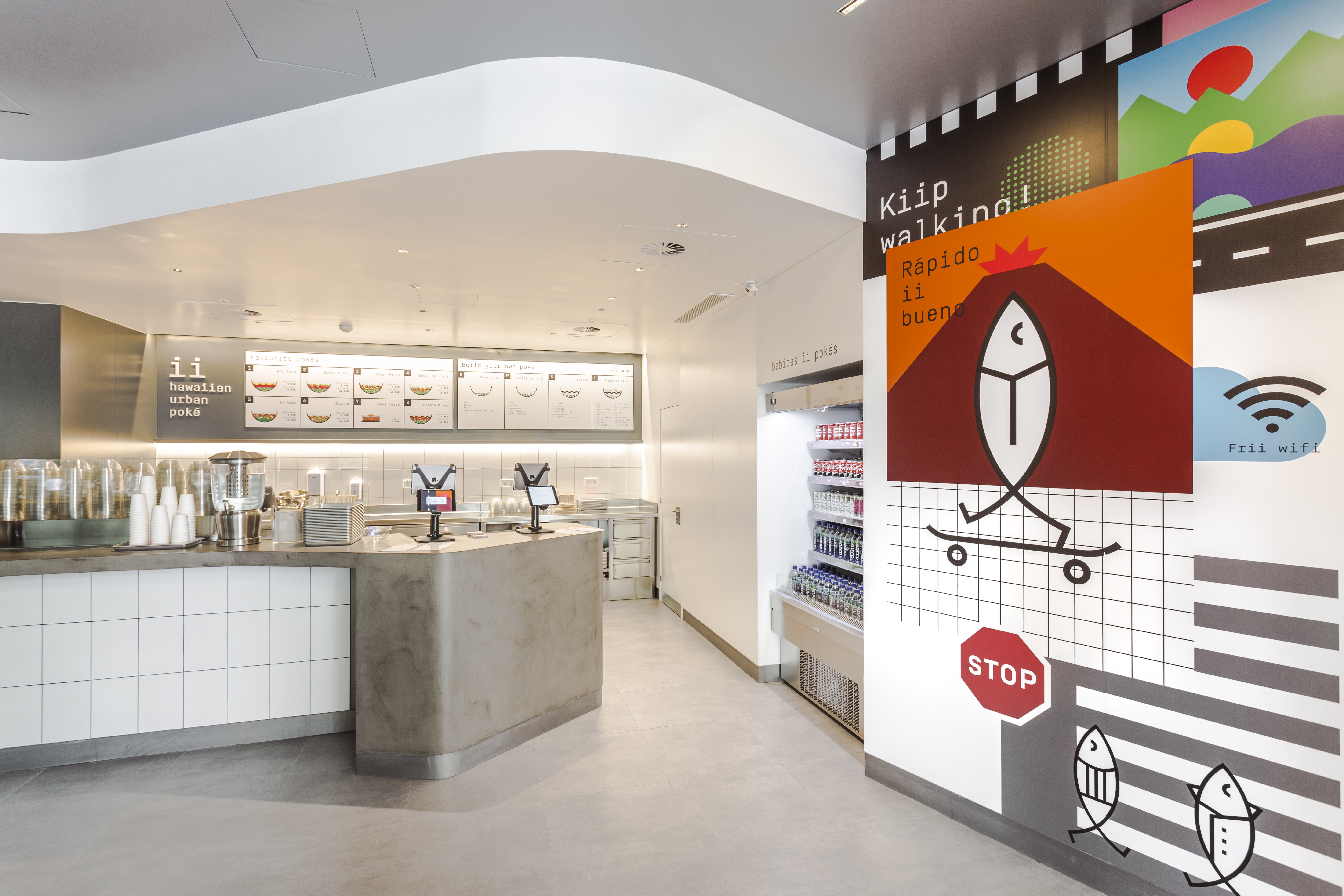 Intérieur de café moderne avec carrelage de sol gris clair et comptoir carrelé blanc.