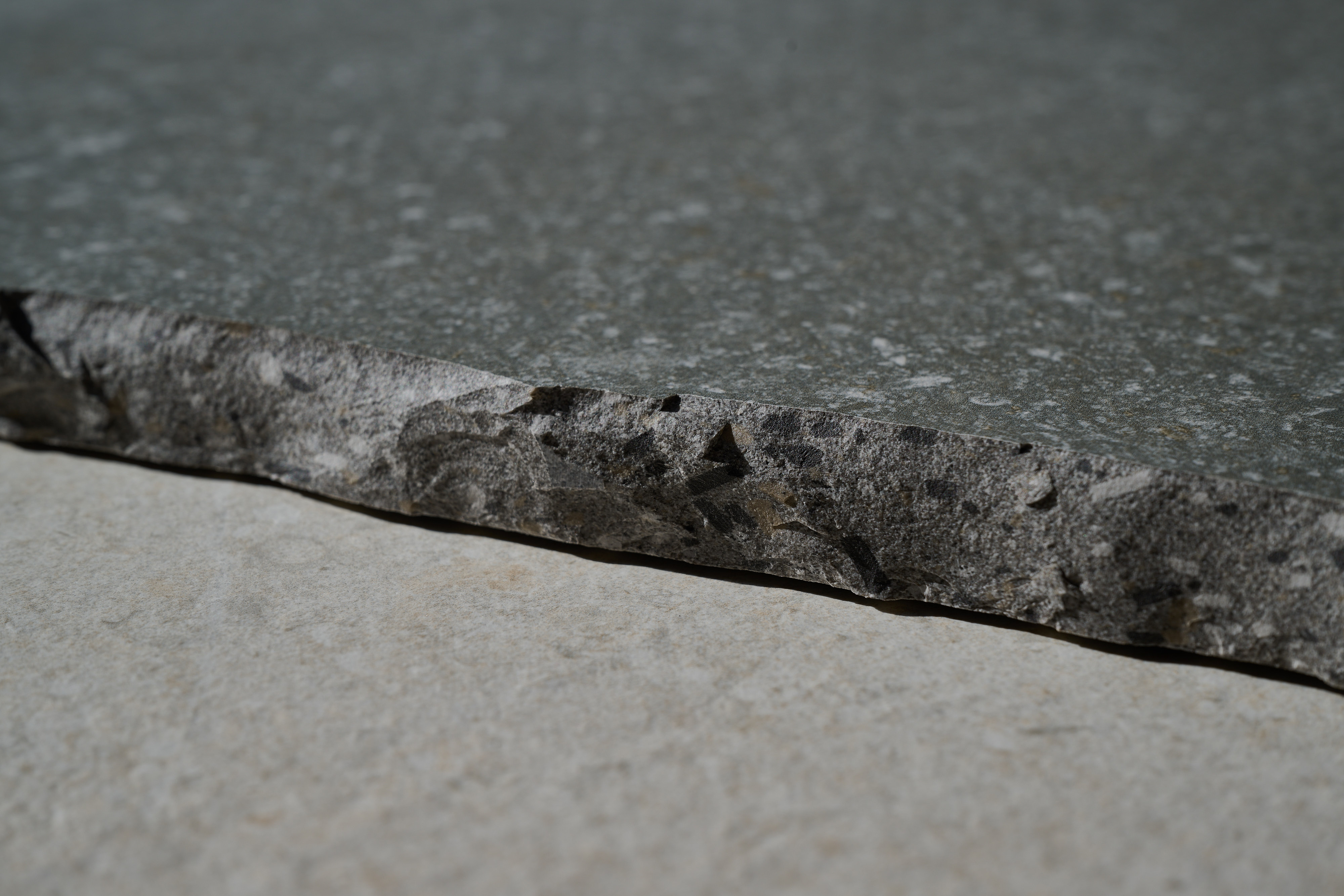 Bord brut de carreau anthracite texturé.