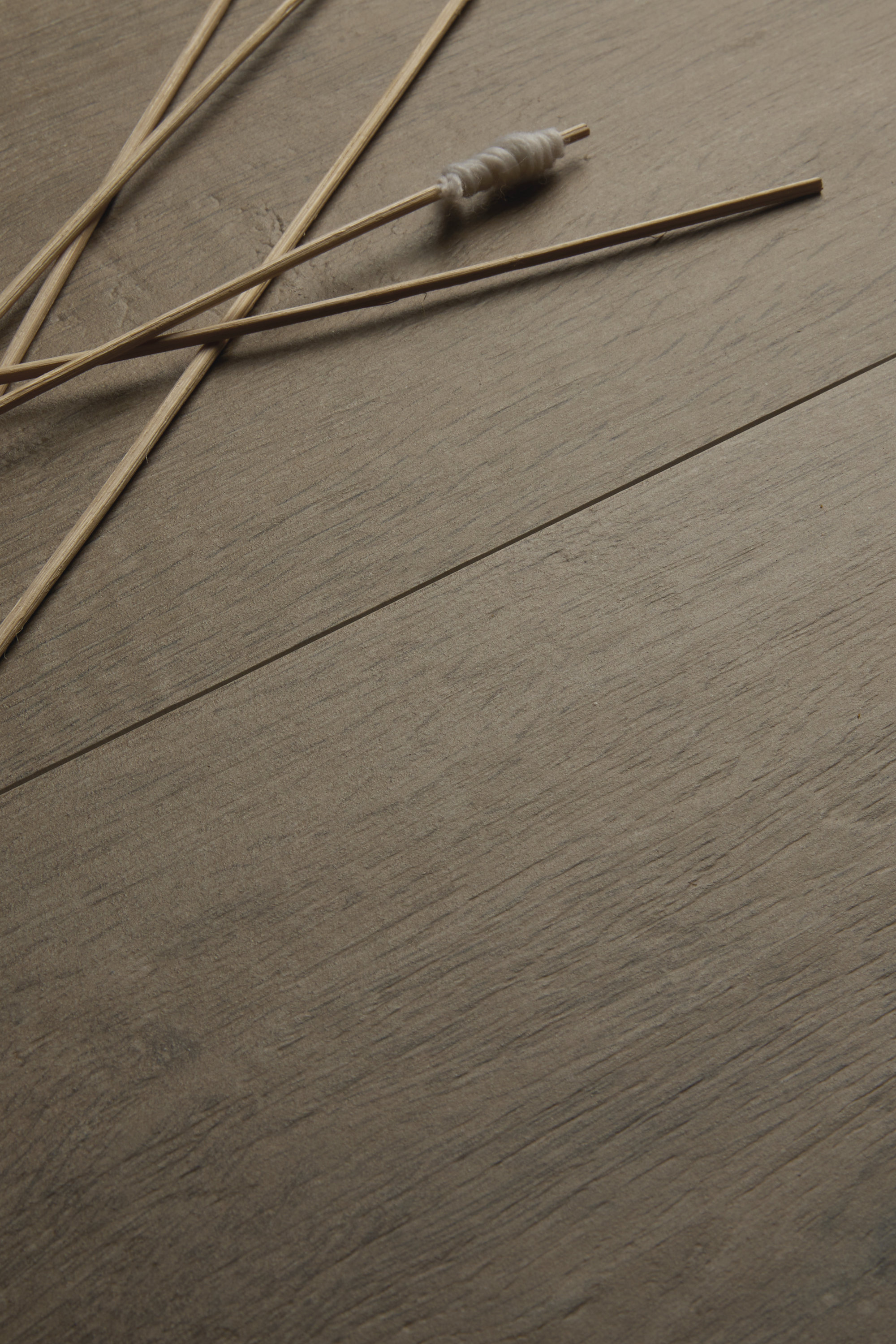 Carreaux gris aspect bois avec veinage naturel.