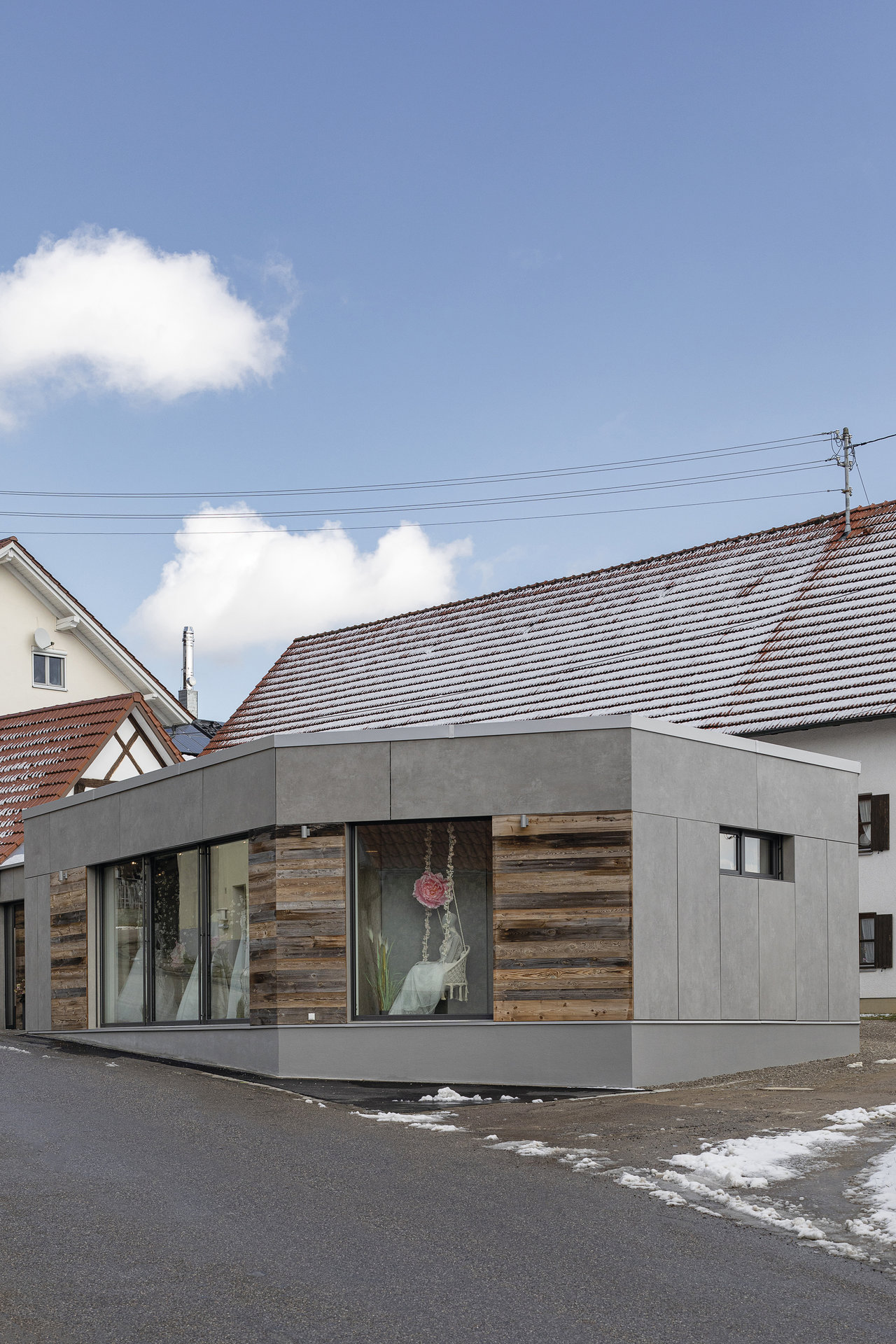 Bâtiment moderne avec façade grise et revêtement en bois, inspiration pour projets de carrelage.