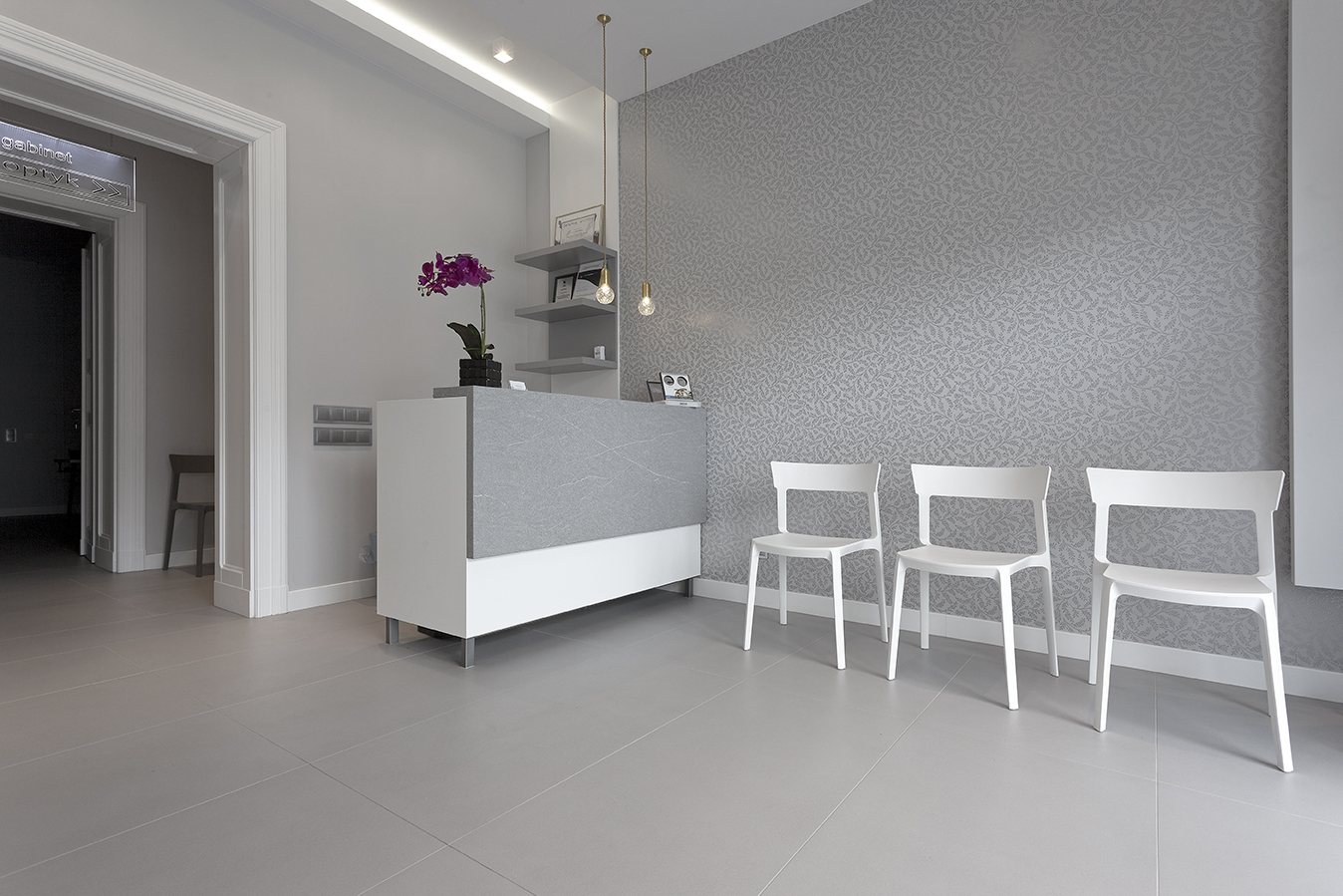 Réception moderne avec carreaux de sol gris clair et mur structuré.