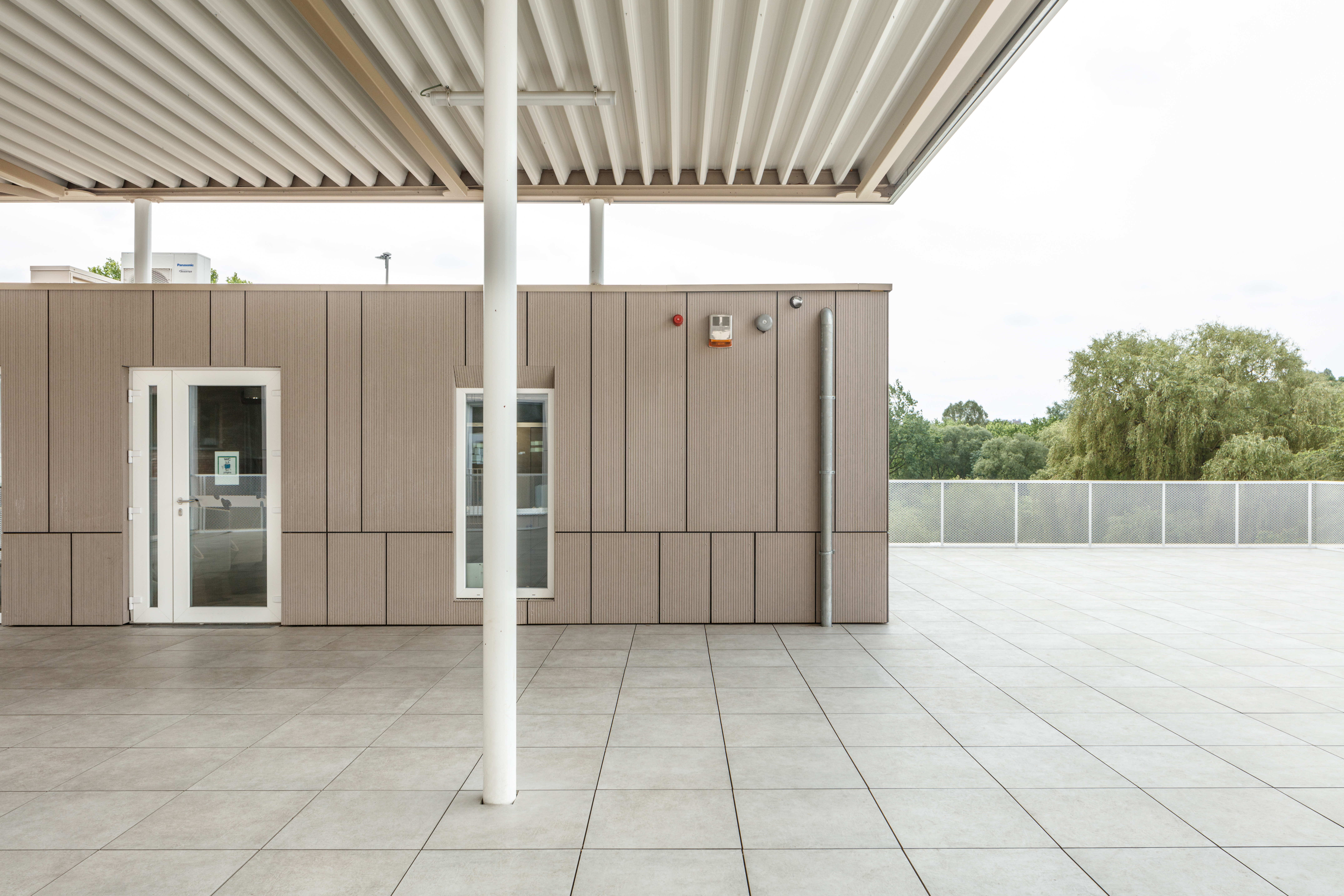 Carreaux de terrasse gris intemporels sous un auvent, idéaux pour l'extérieur.