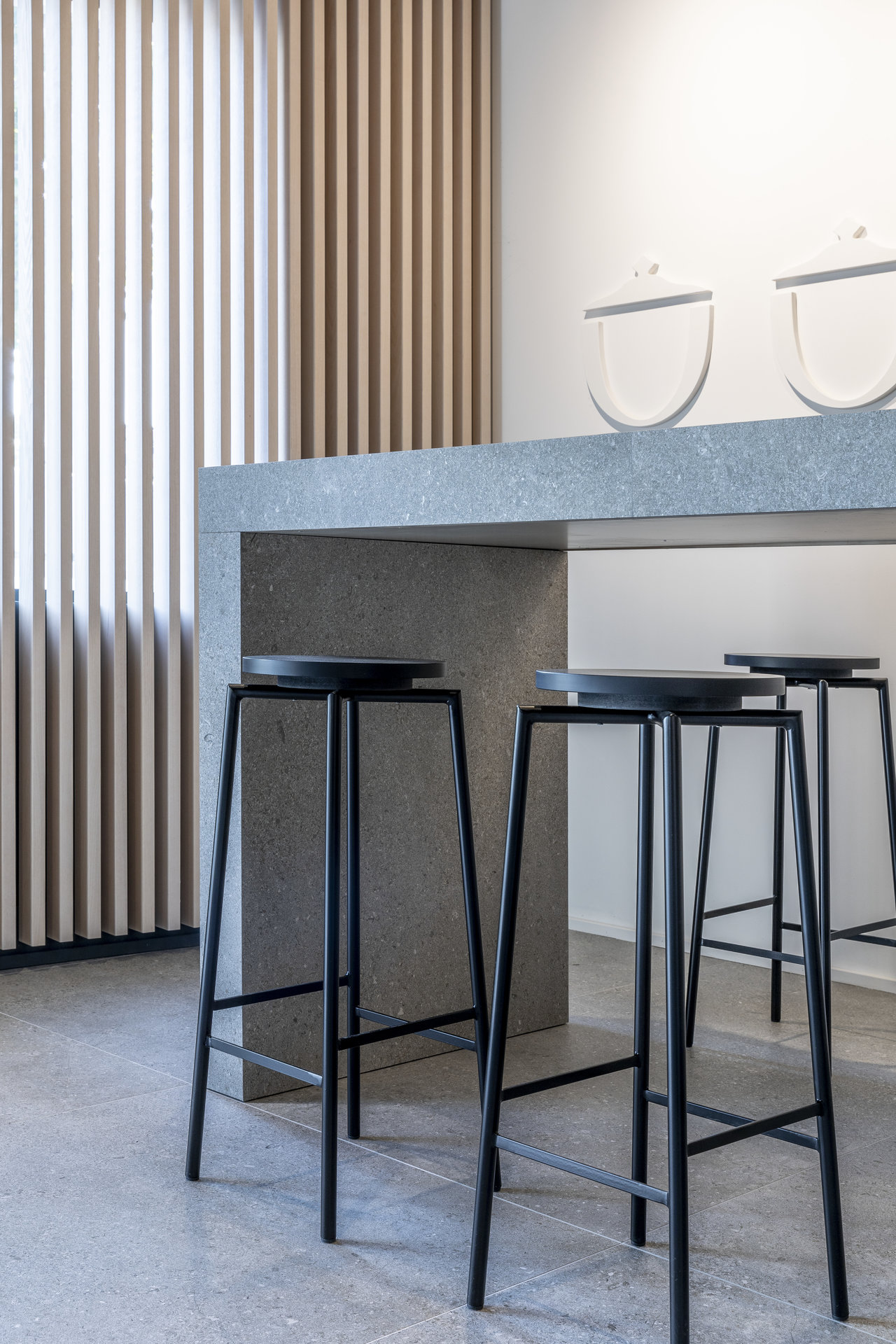 Pièce moderne avec carrelage gris effet béton et comptoir assorti.