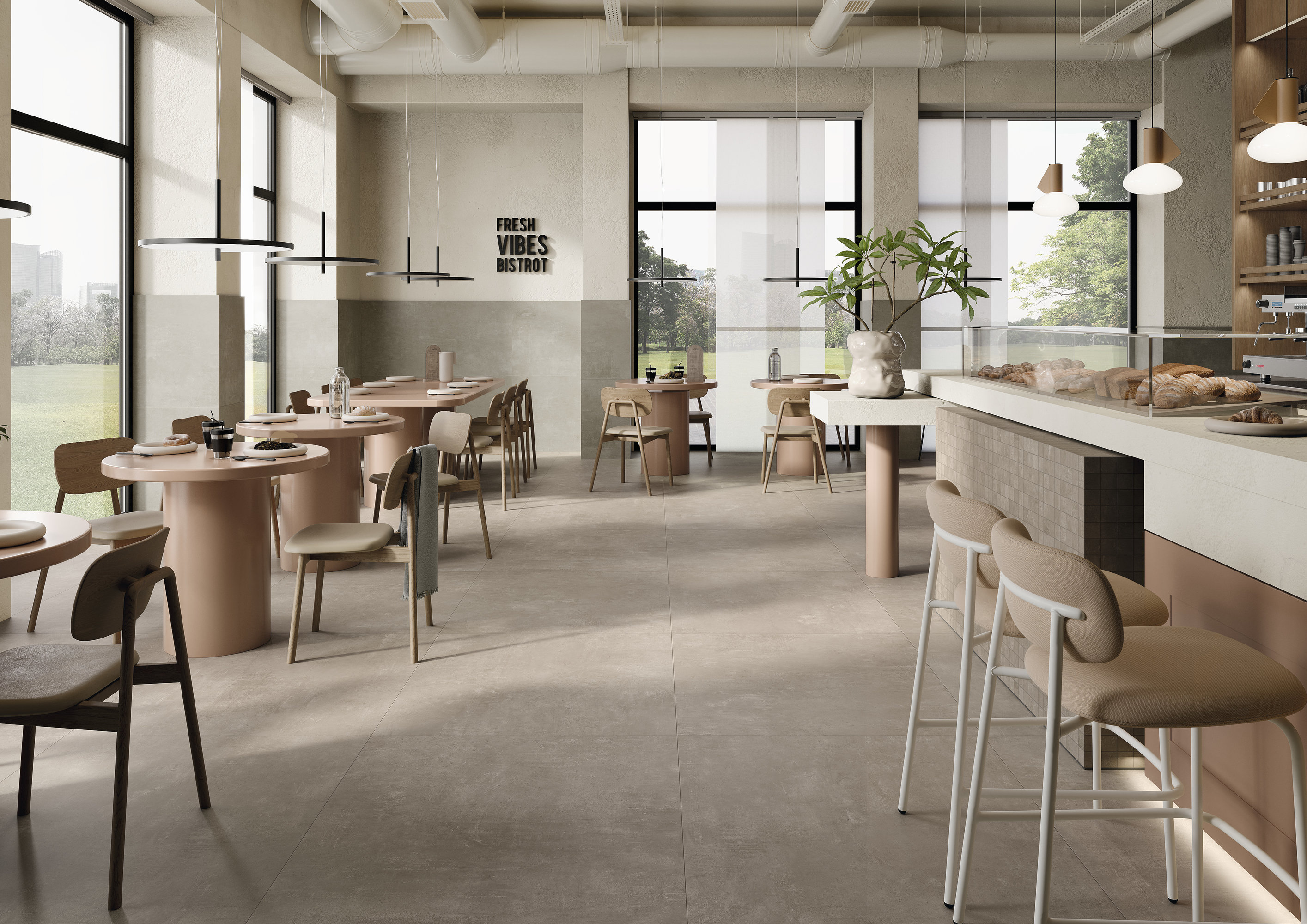 Café moderne avec carreaux de sol grand format gris clair, effet béton.